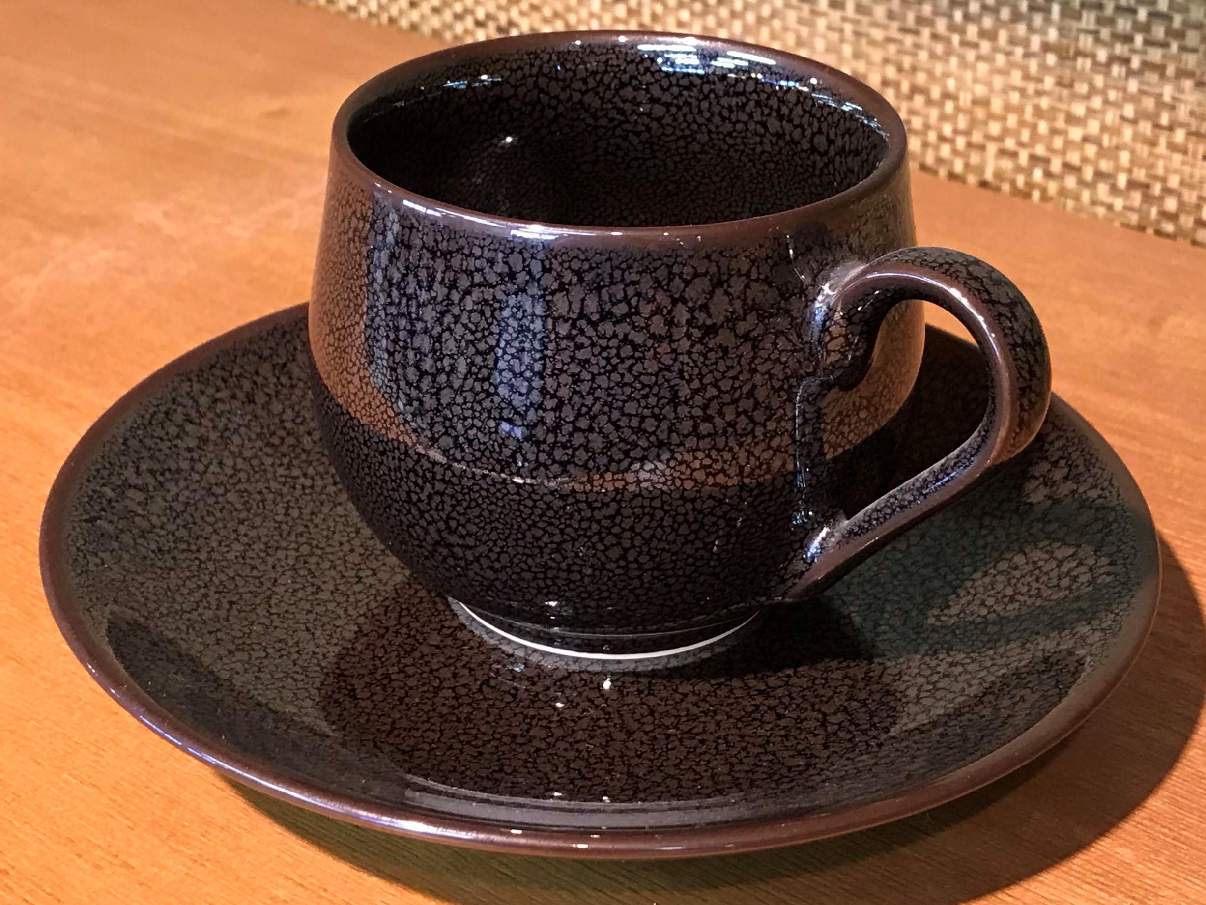 Unique contemporary Japanese porcelain cup and saucer, hand-glazed in stunning signature brown on a black background, a signed work by highly acclaimed award-winning master porcelain artist from the Imari-Arita region of Japan. 

In this