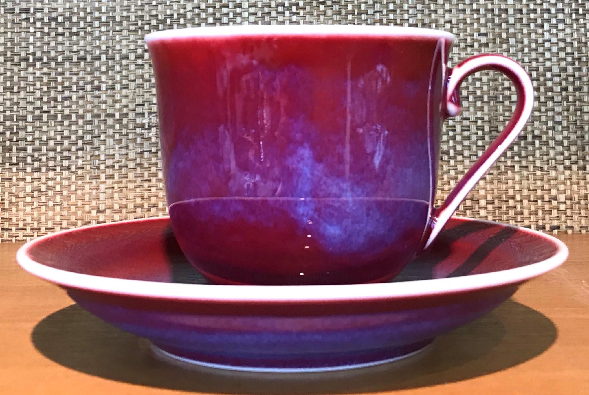 Exceptional Japanese contemporary porcelain cup and saucer, hand-glazed in a stunning signature red with blue clouds on a beautifully shaped body. This is a signed work by a highly acclaimed award-winning master porcelain artist from the Imari-Arita