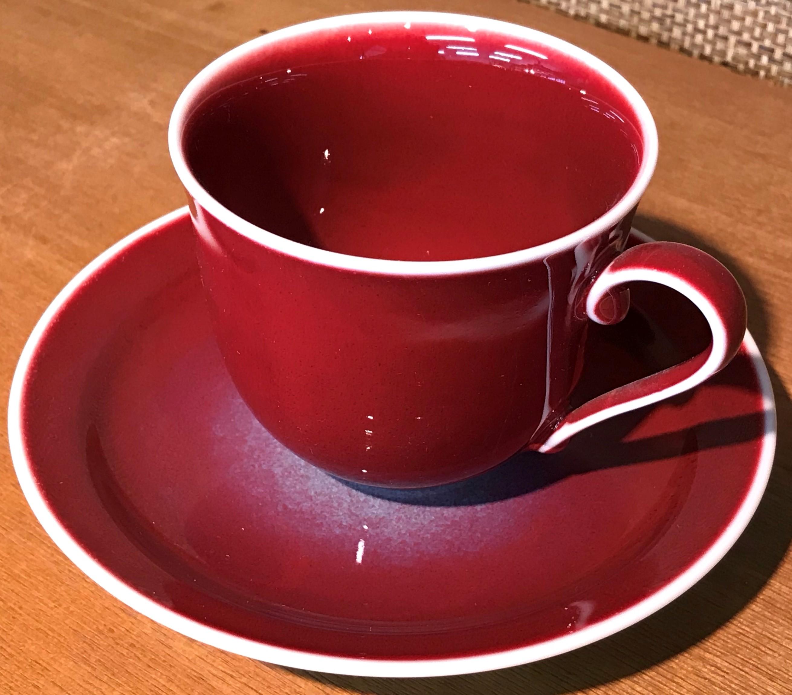 Exceptional Japanese contemporary porcelain cup and saucer, hand-glazed in a stunning vivid ruby red on a beautifully shaped body. This is a signed work by a highly acclaimed award-winning master porcelain artist from the Imari-Arita region of