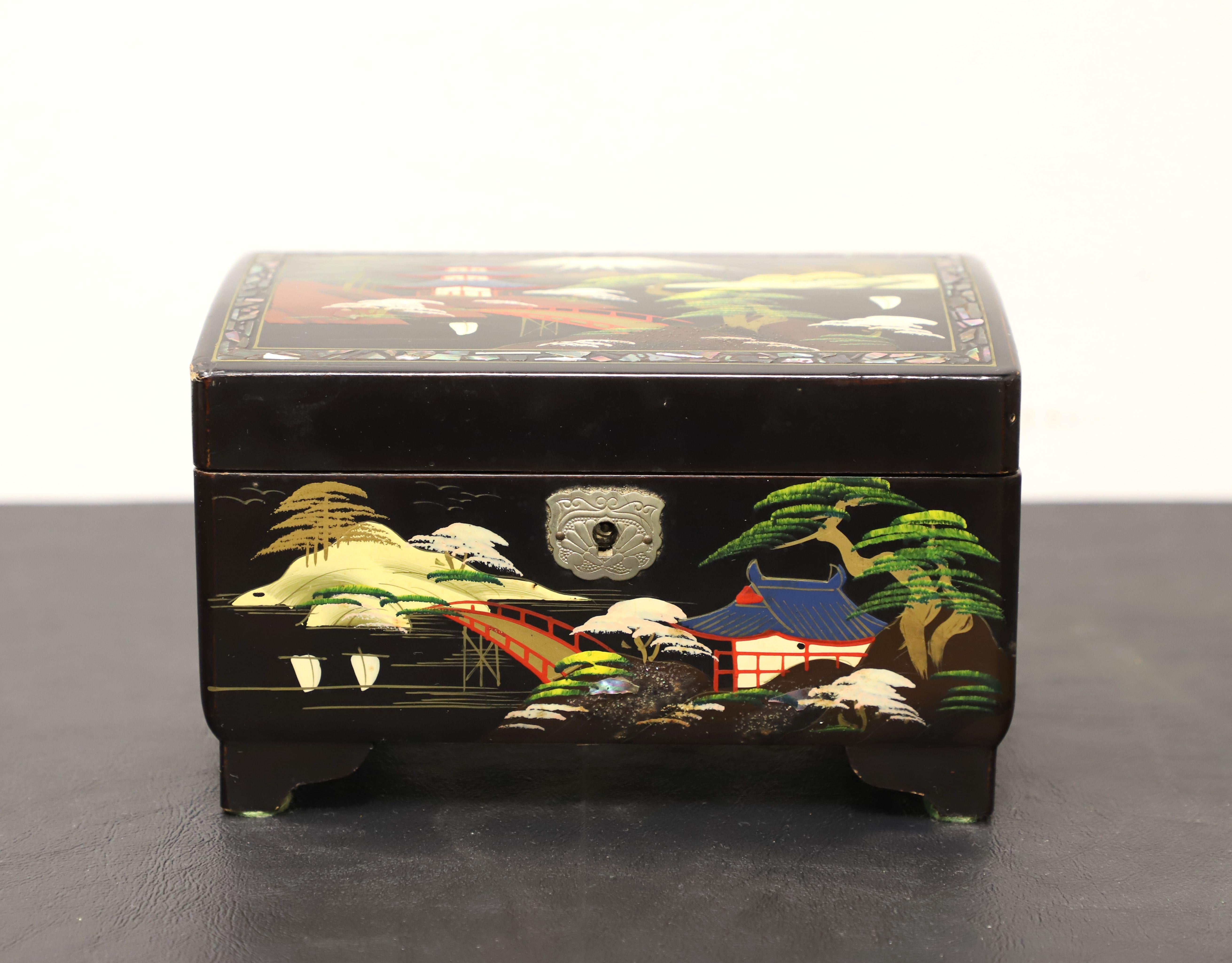 A decorative Japanese style jewelry box, unbranded. Wood with black lacquer, hand painted Japanese scenes, metal hardware, and is footed. Features interior side of lid with hand painted mirror, a felt lined lower interior, a hinged lift-up upper