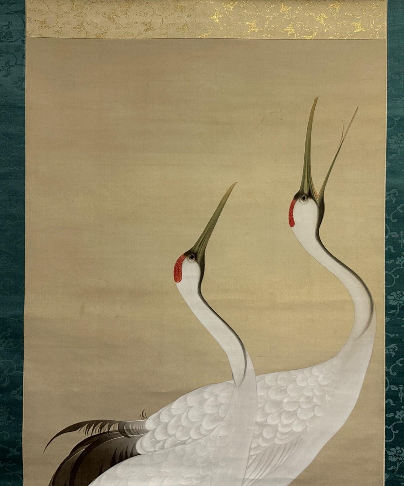 A superb and masterfully painted Japanese kakejiku (hanging scroll) from the early Taisho period, featuring an elegant depiction of a pair of cranes—revered symbols of longevity and good fortune in Japanese culture. The artwork is executed with