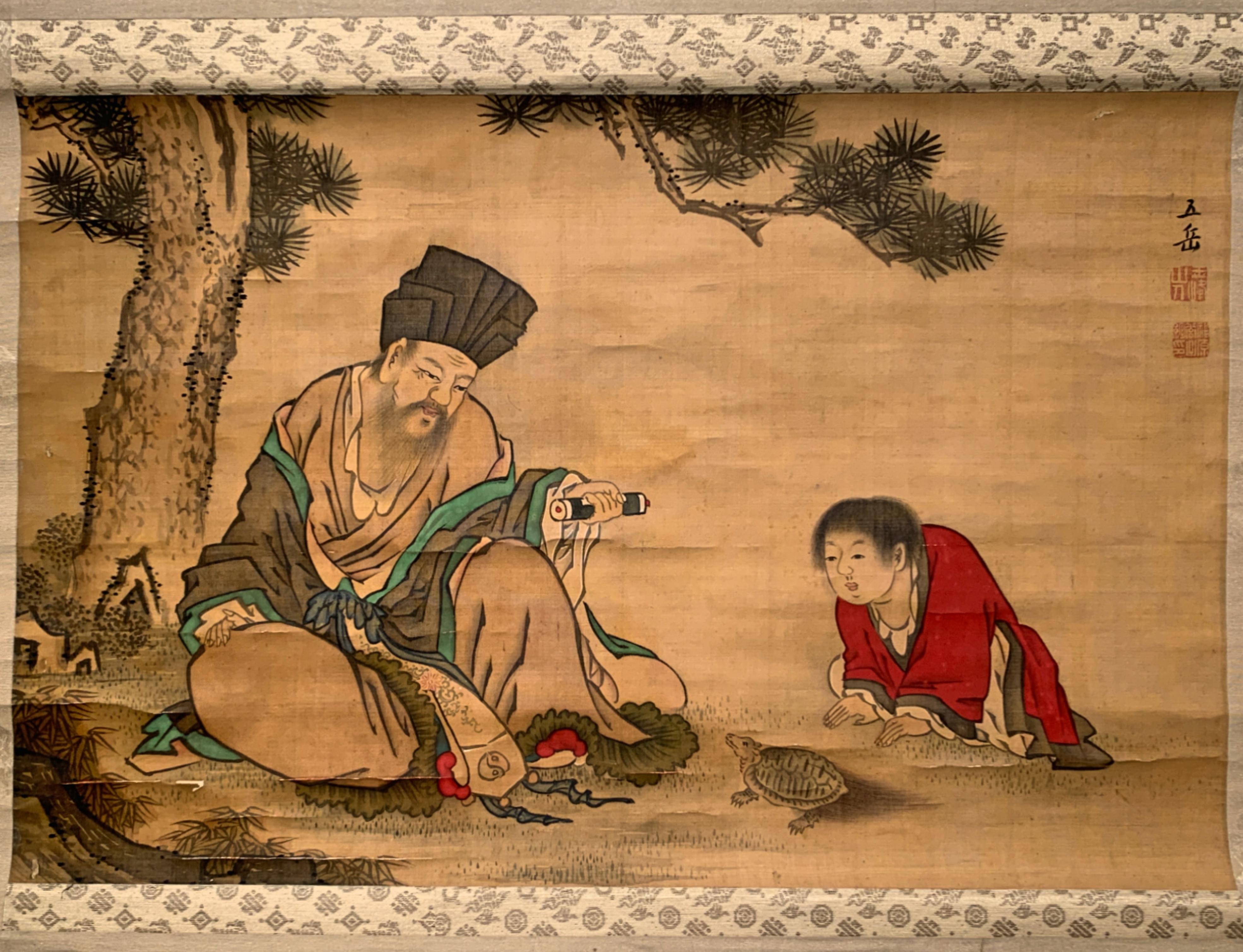 A Japanese hanging scroll painting, kakemono or kakejiku, of a Taoist scholar and student, by Fukuhara Gogaku (1730-1799), ink and color on silk, signed Gogaku, with two seals of the artist, Edo Period, late 18th century, Japan. 

The painting