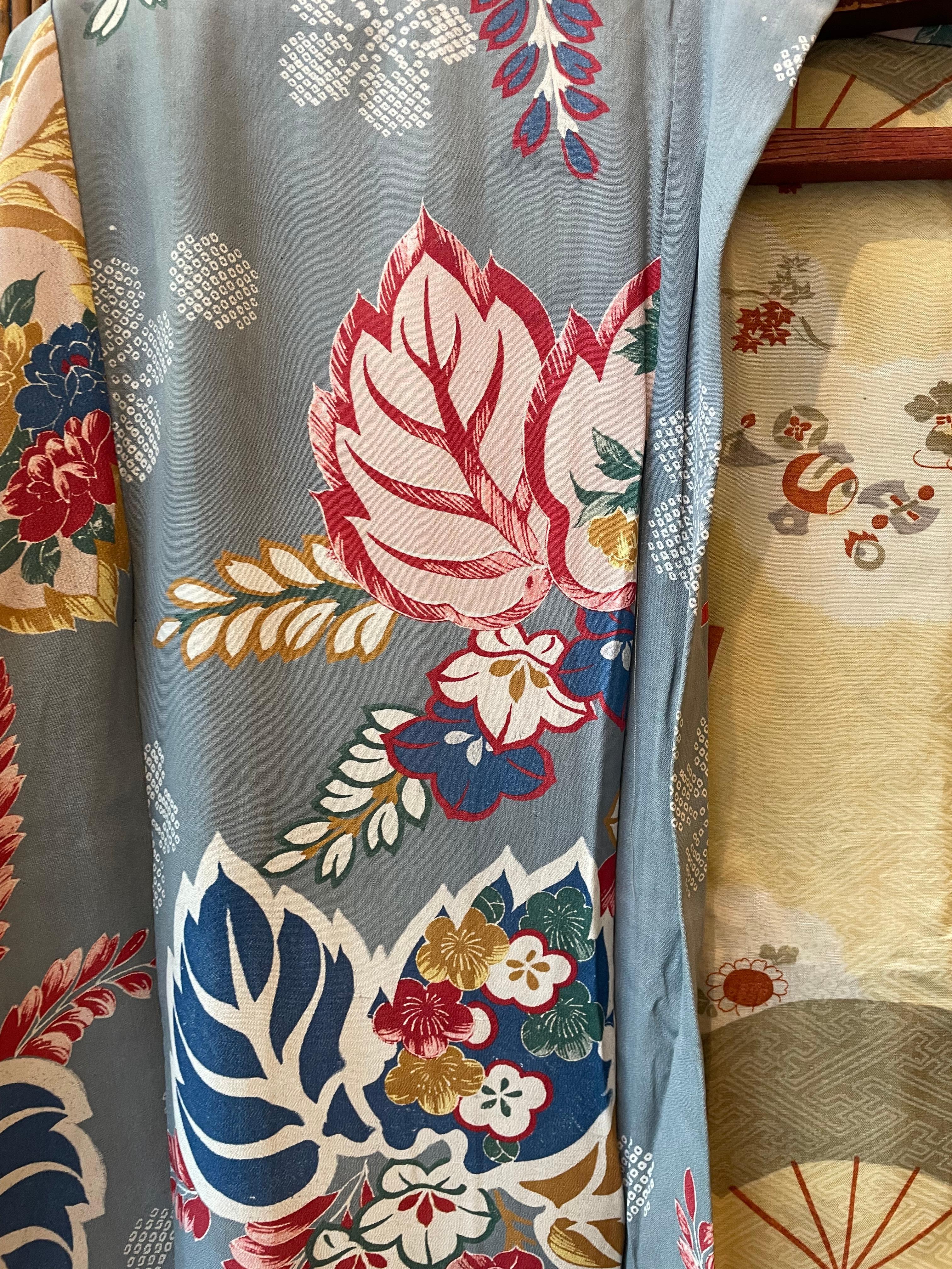 This is a silk jacket which was made in Japan.
It was made in Showa era around 1950s.
The main colour is sky blue but these flowers are in several colours. 
There is two haori himo to close this jacket. 

The haori is a traditional Japanese