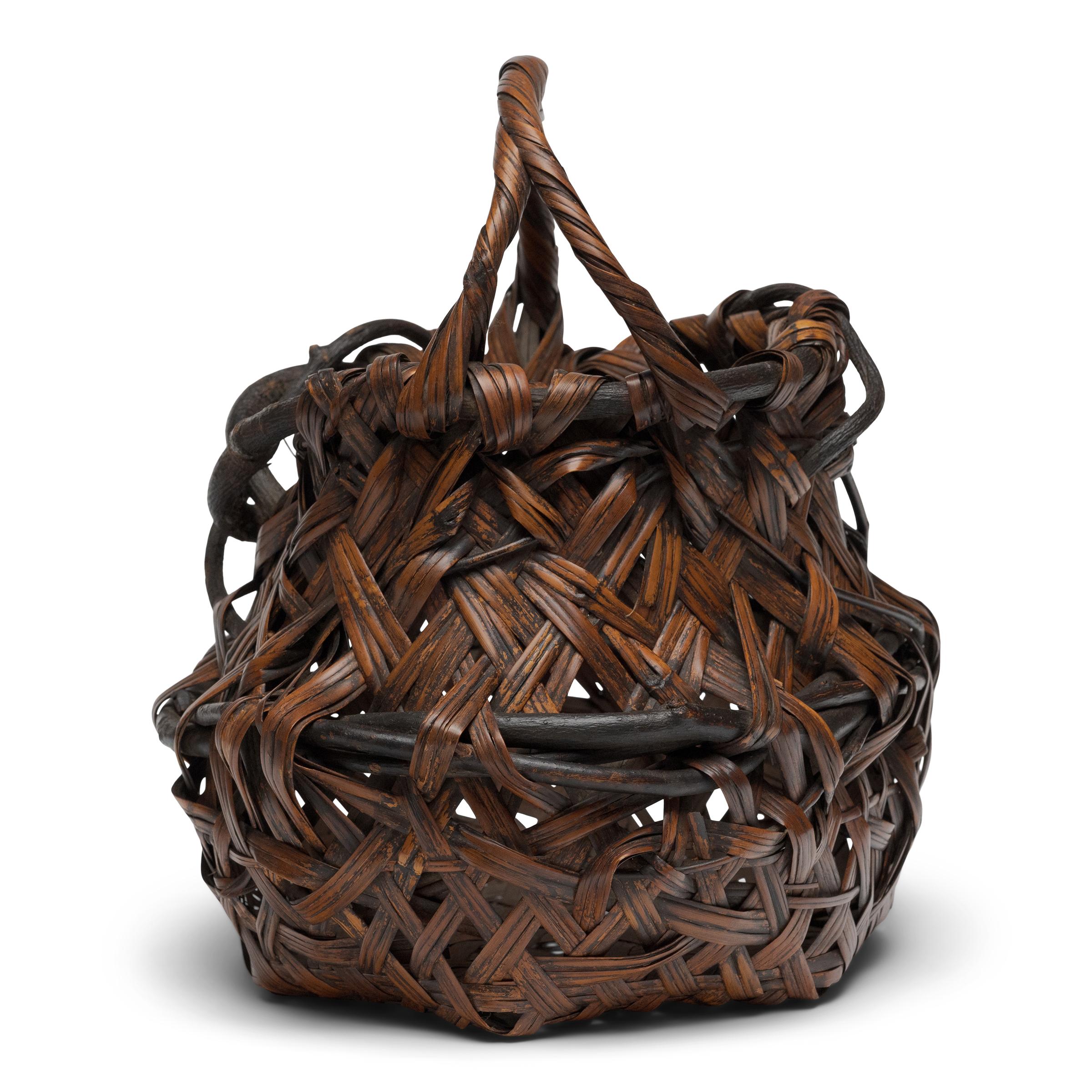 This incredible bamboo basket is a late-Meiji period flower basket (hanakago) designed especially for ikebana, the Japanese art of floral arrangement. The gorgeous basket is masterfully woven of smoked bamboo (susutake), a desirable material that