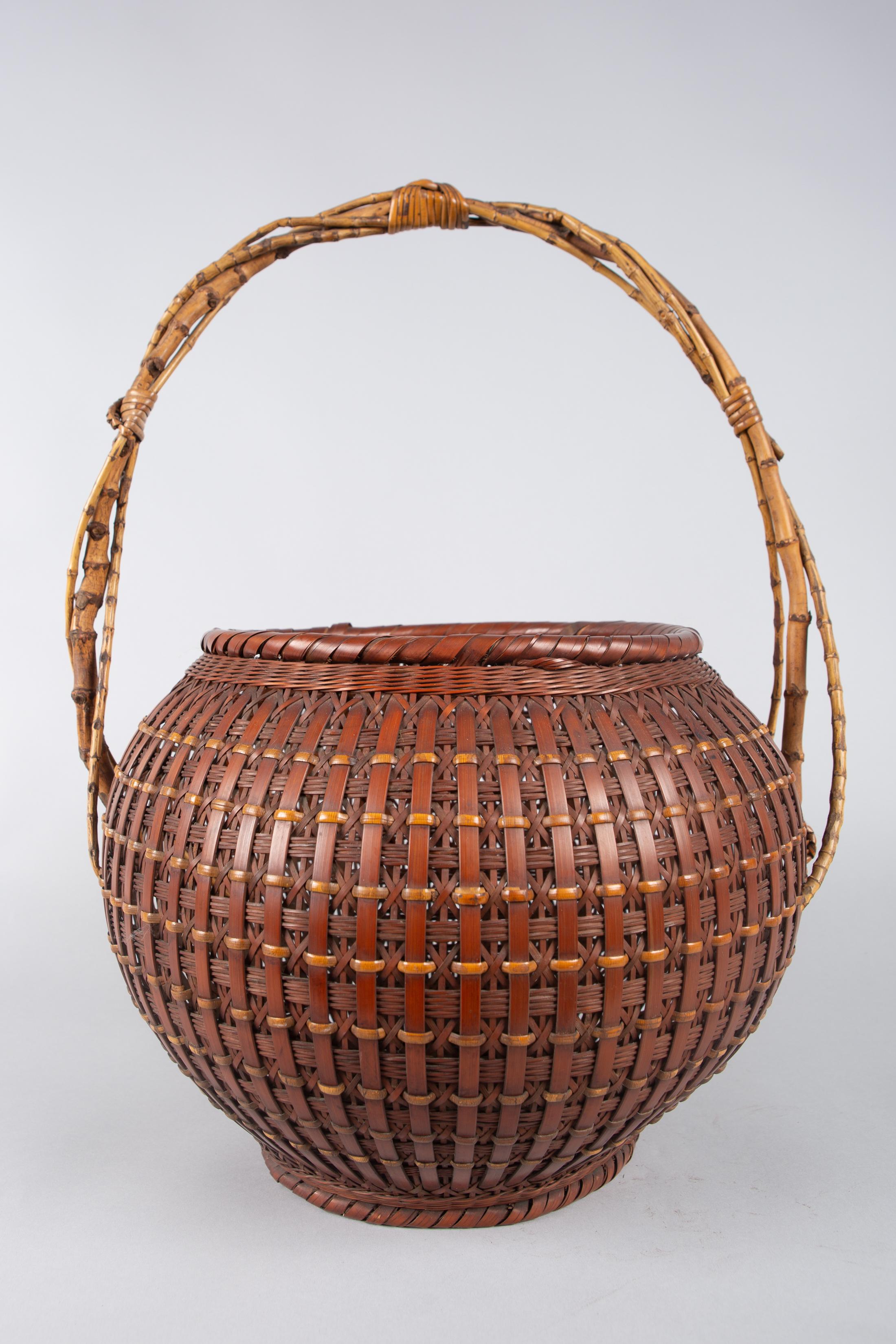 Japanese Ikebana (Flower Arranging Basket), Signed by Teijo Sai (the artist) on the bottom.
Meiji Period (1868-1912) ikebana made of smoked bamboo, polished with ash. Very nice weaving. Handle made of young twisted and bound bamboo. Comes with