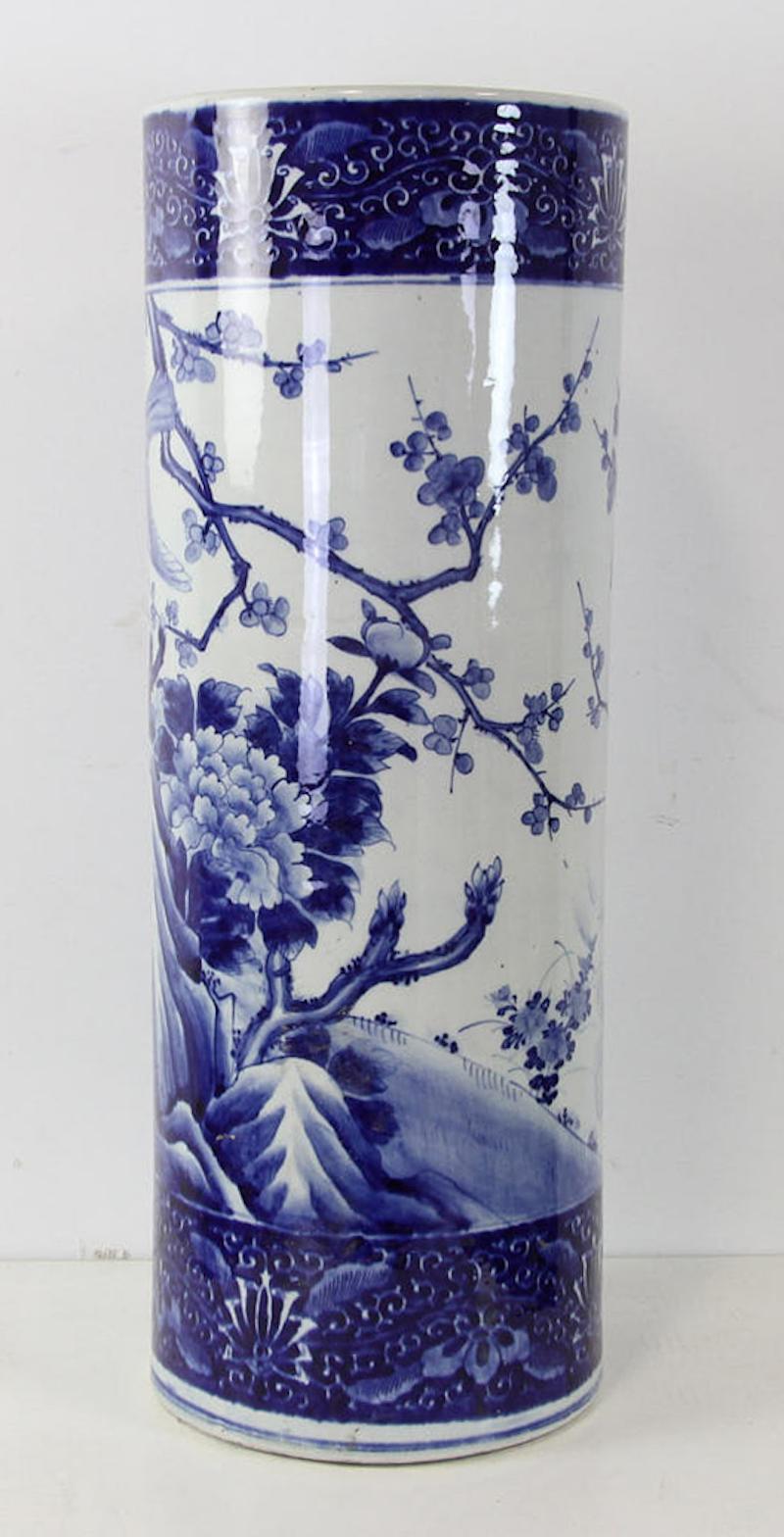 Antique Japanese Imari umbrella stand, Cobalt Blue, and white with banded design around the top and bottom. DEcorated with branches of cherry blossoms, bird, and large chrysanthemum flowers. Measures 24
