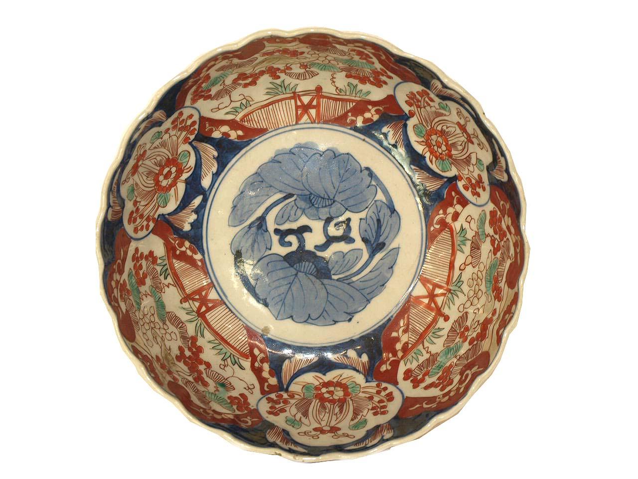 Japanese Imari bowl, with red, blue and teal colors, the center with stylized blue flowers, and various scenes on the interior and exterior featuring an inquisitive rabbit, flowers and foliate. The base diameter is 6 inches, in very good condition.