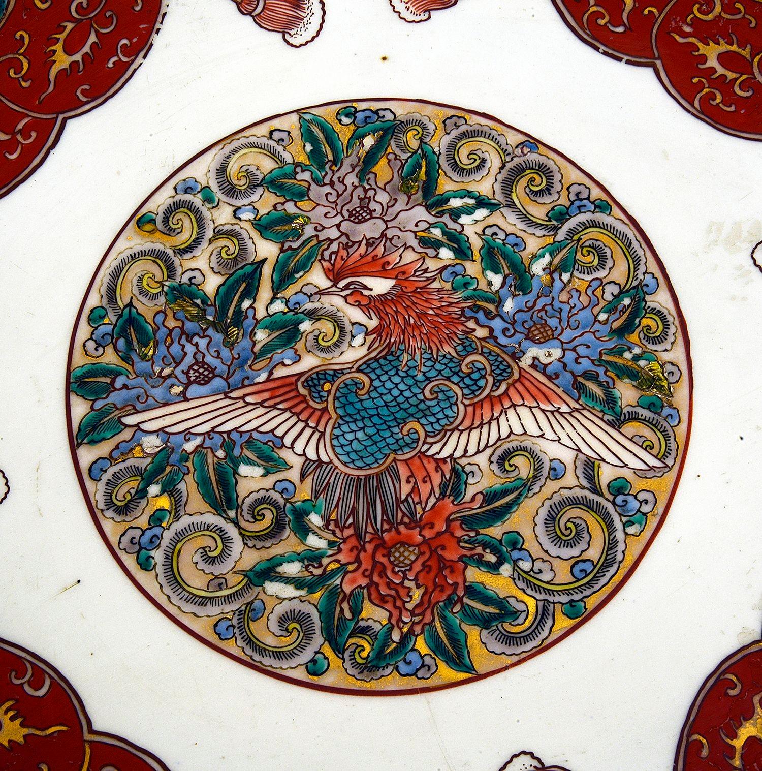 Ein auffälliges japanisches Imari-Geschirr aus dem späten 19. Jahrhundert mit klassischen Motiven auf rotem Grund, vergoldeten Highlights und einer zentralen Tafel, die einen mythischen exotischen Vogel darstellt.

Charge 82 N/H