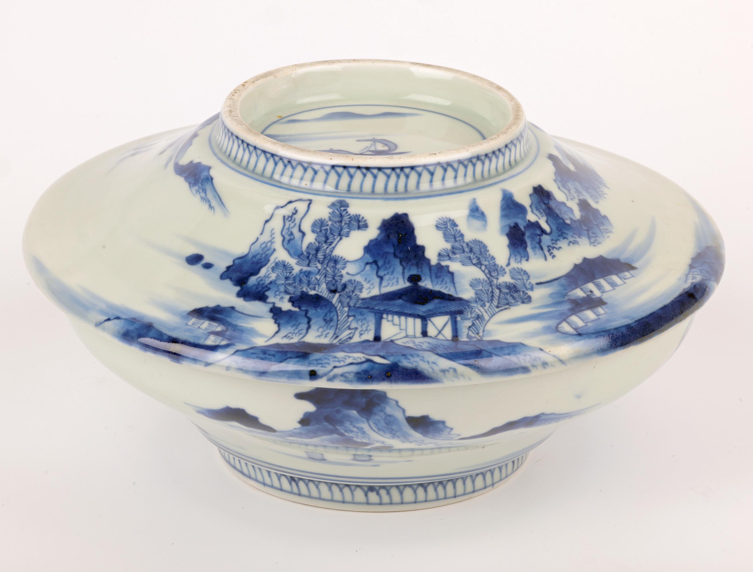 Un très élégant plat à riz et son couvercle en porcelaine japonaise peinte en bleu et blanc de la période Edo, décorés de paysages aquatiques, datant d'environ 1850. La coupe est de forme ronde et large et repose sur un pied rond étroit avec un