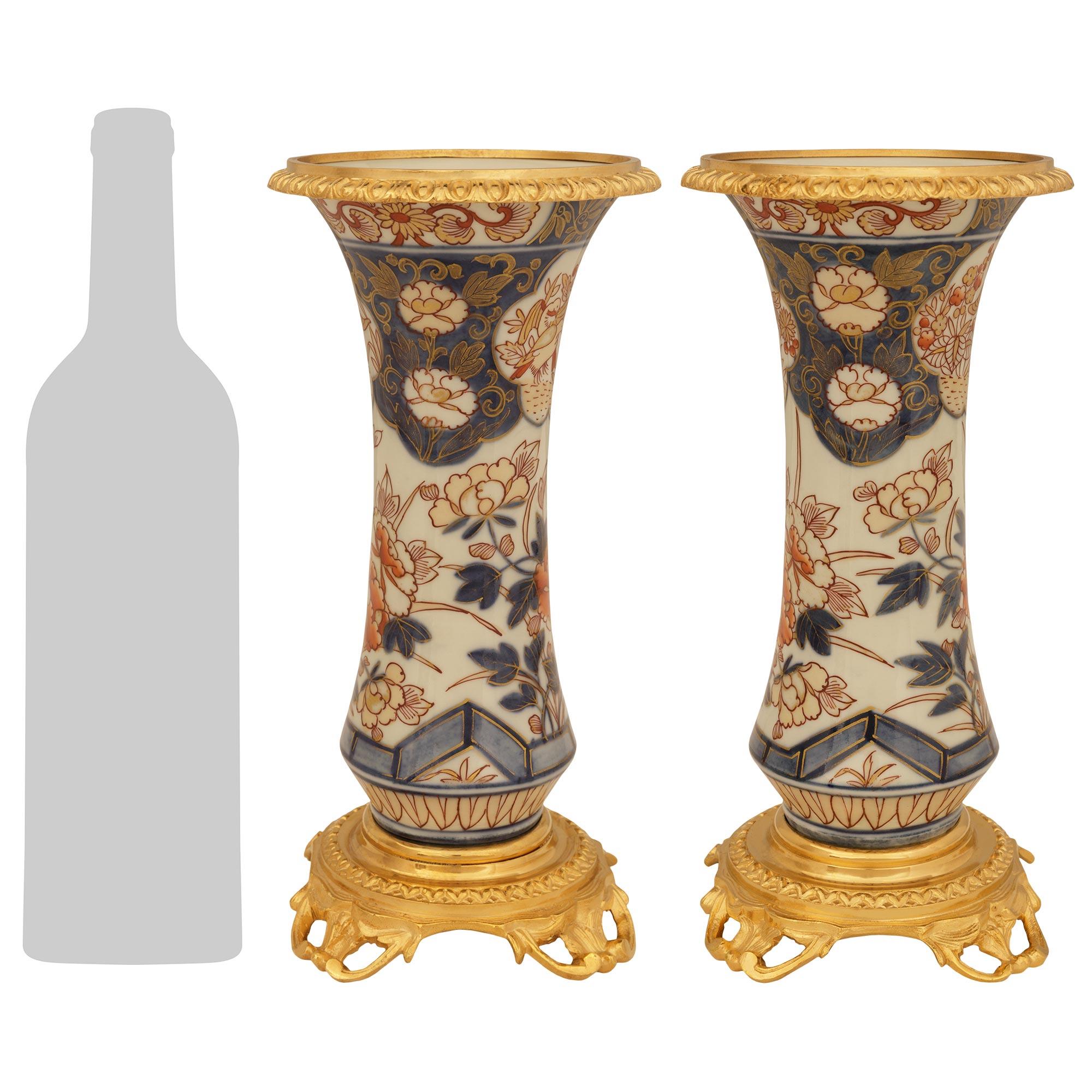 An elegant and most decorative pair of Japanese 19th century Imari Porcelain and French Louis XV st. Ormolu mounted vases. Each colorful vase is raised by a pierced Ormolu base with an upper mottled circular band and supported on scrolling foliate
