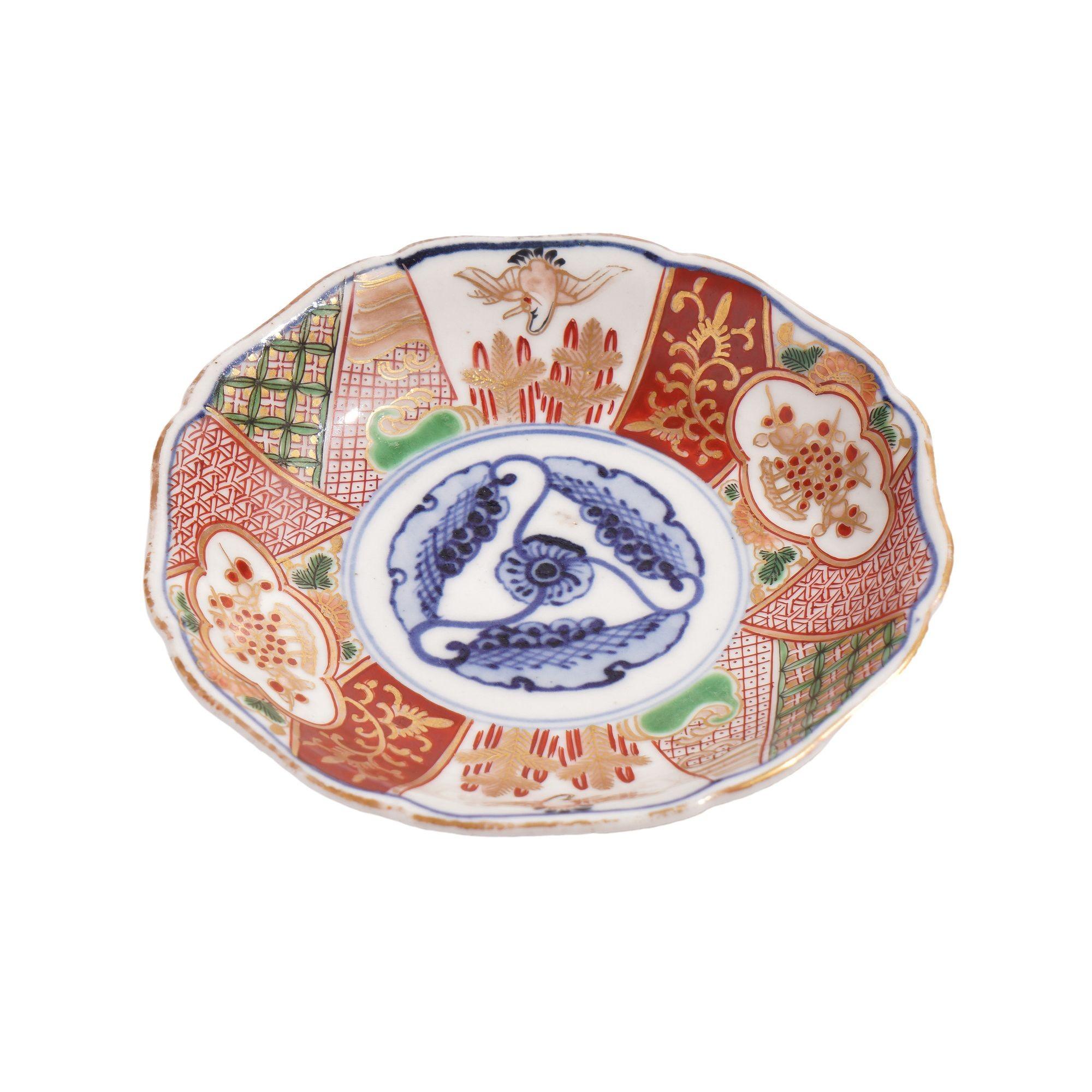 Japanese Imari porcelain footed saucer with under rim and signature in cobalt under glaze blue. The face of the saucer is decorated with a cobalt blue trim-foil design with surrounding rim decorated inn Imari pattern of oxide red, green and gilding.