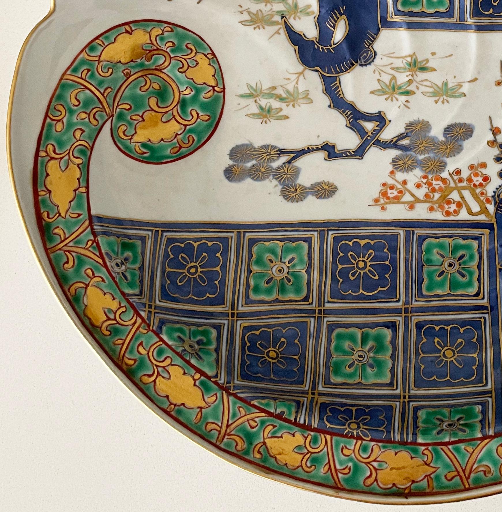 A beautiful hand-painted Japanese Imari contoured glazed shell dish with fluted edge to the top half, profusely decorated in geometric floral patterns with a sweeping vine scroll and prunus in vibrant shades of blue, orange, green and white with
