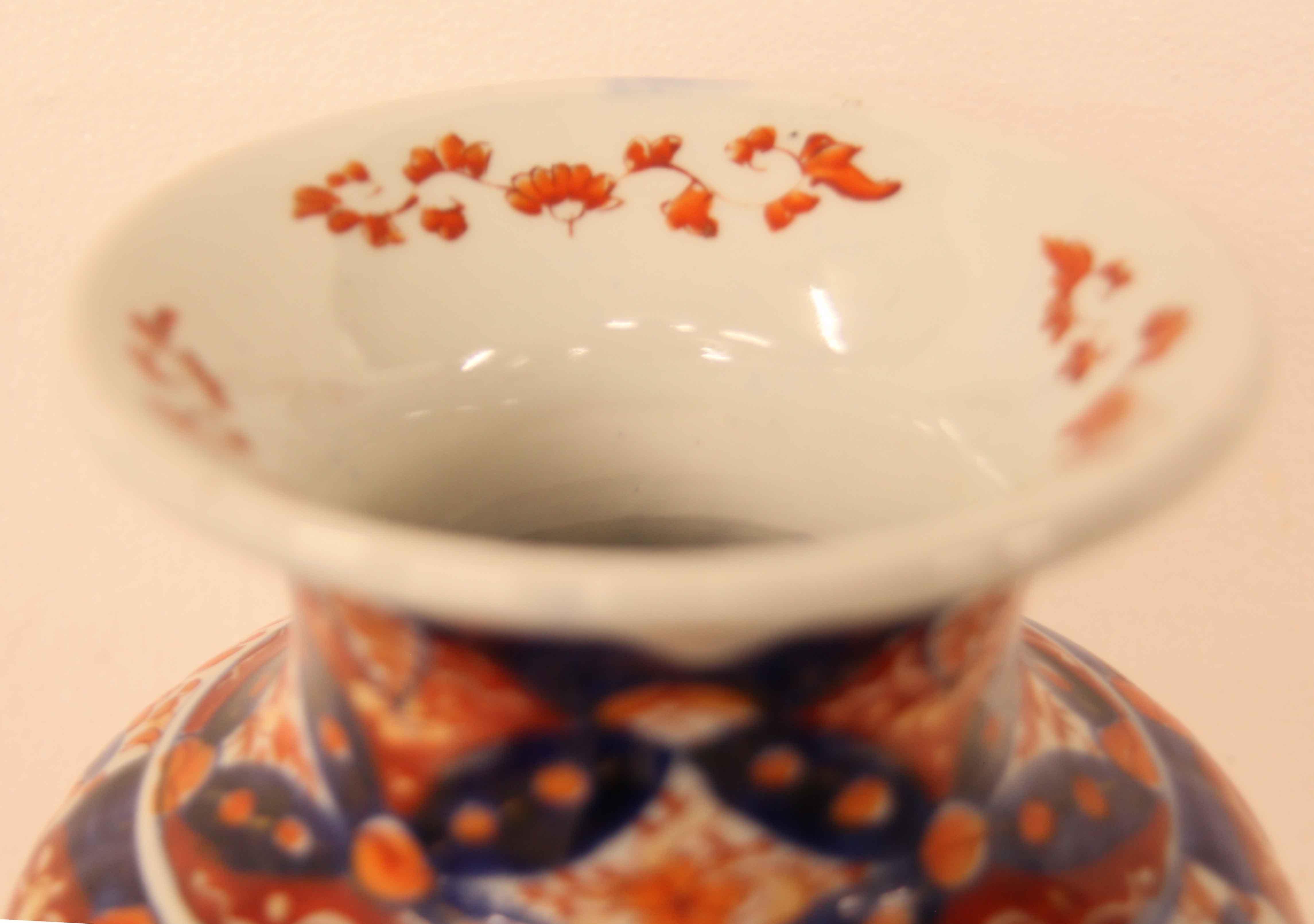 Japanese Imari vase,  the interior rim is sparsely painted with stylized flowers and foliate, the baluster shaped body is boldly and profusely decorated with stylized flowers, foliate, birds and other typical Imari motifs.  The lower portion (below