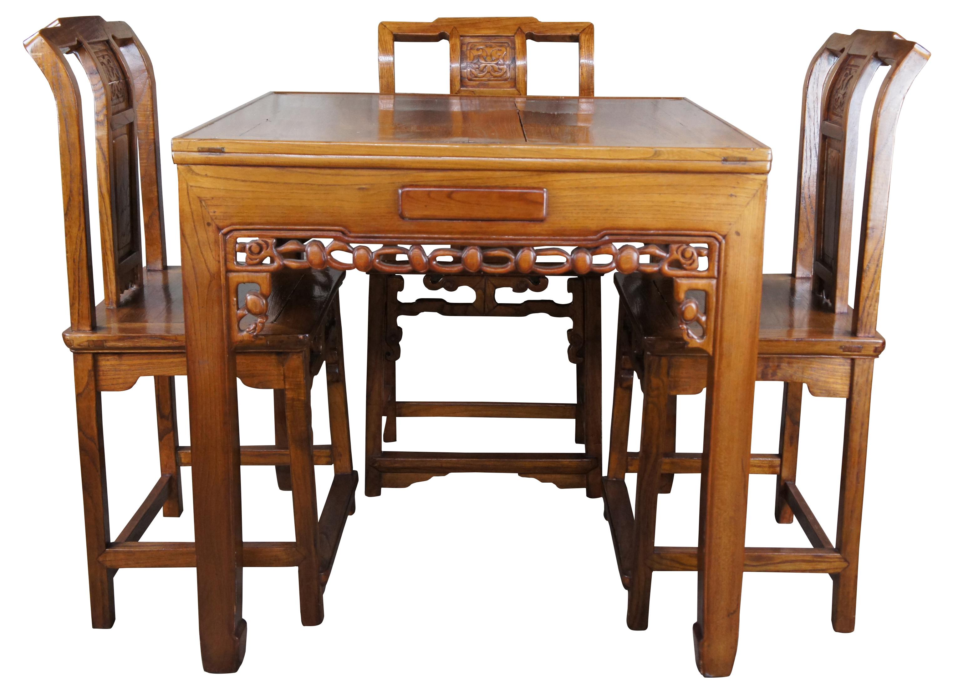 A beautiful Japanese solid elm Mahjong table and 4 chairs.. Purchased in Japan during the last quarter of the 20th century. Table features Square form with carved and pierced apron. Includes a dovetailed drawer along each side and a glass top.
