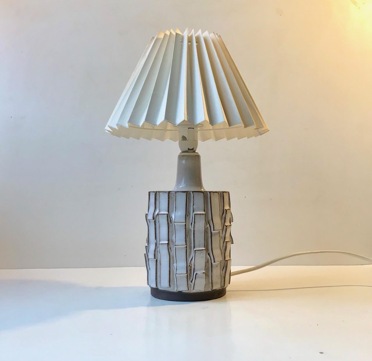 A Japanese inspired ceramic table light in a rather tactile shape. It is executed in a white Salt-glaze and its relief decor resembles overlapping wood. Signed GO for Gottschalk-Olsen and cerated at his workshop Stogo in Denmark during the 1970s.