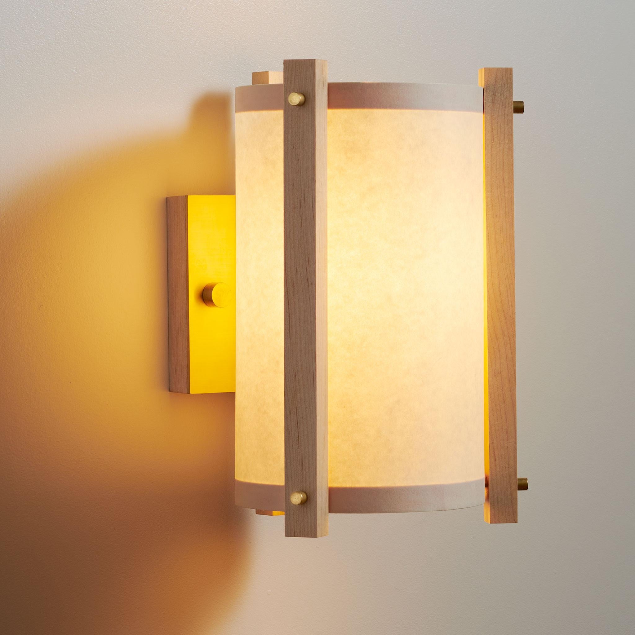 Delicate wall lighting with brass accents brings together a soft glow to any space. With a simple modern design, these sconces can be equally appreciated when illuminated on or off. 

The wood hand cut from a light Marple. Waxed raw brass accents