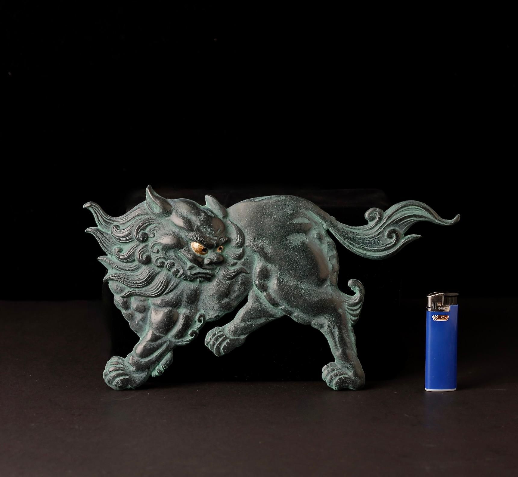 An exquisitely crafted iron plate featuring a dynamic and finely detailed depiction of a Shishi (mythical lion-dog). The figure is portrayed with expressive movement and intricately rendered fur, reflecting expert craftsmanship and powerful