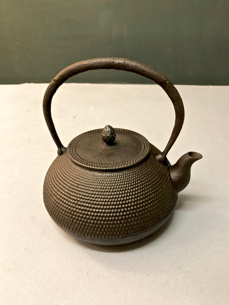 This is a good example of an early to mid-20th century Japanese iron teapot. This Tetsubin or tea ceremony tea pot dates to the late Meiji or early Showa period and is in very good condition. The pot features a raised dot design, arched forged