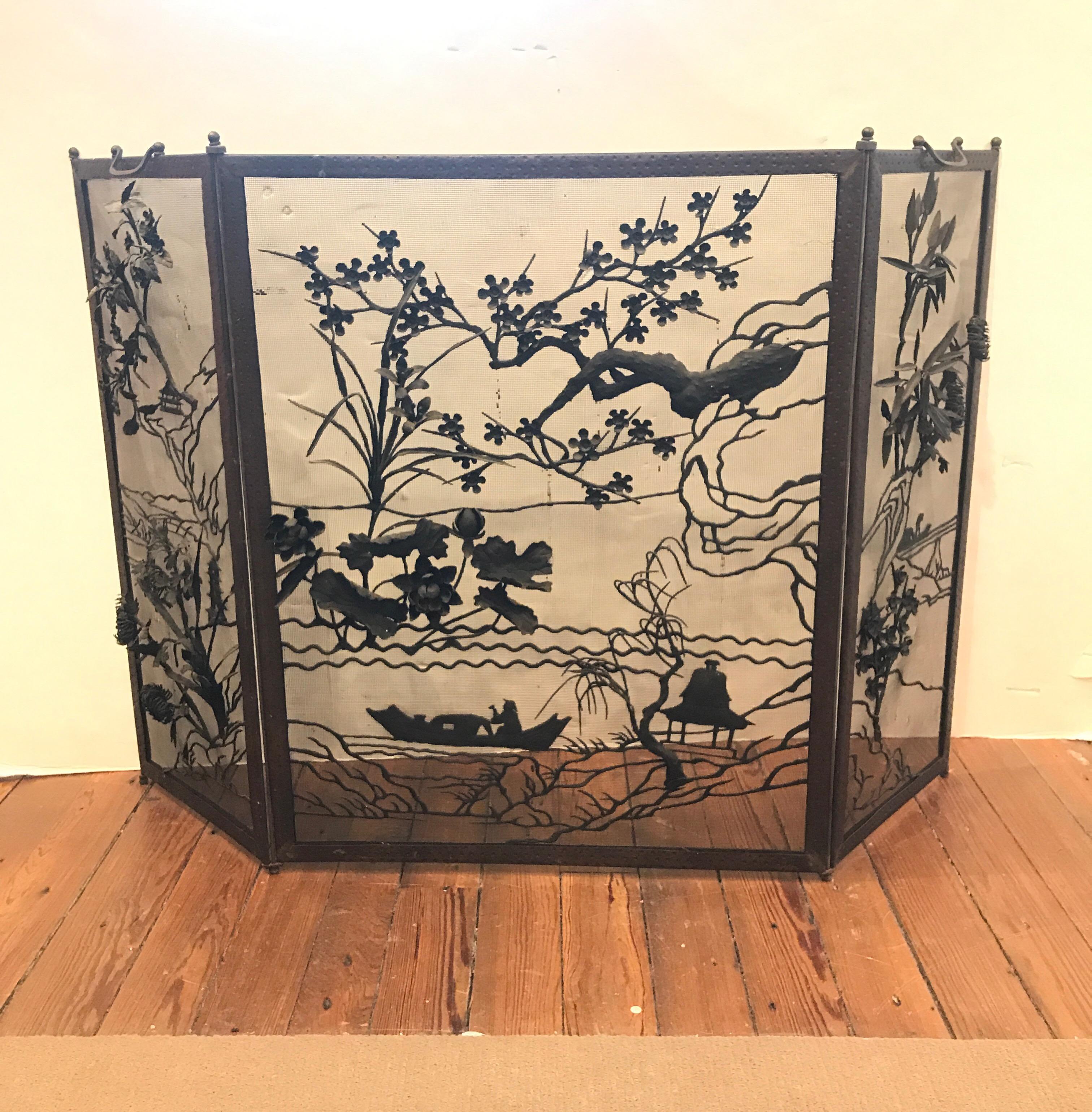Incredibly detailed Japanese fire screen with three dimensional decoration on the three panels. The panes with a fisherman in a boat with tree branches and detailed floral design. Original condition with an aged patination.