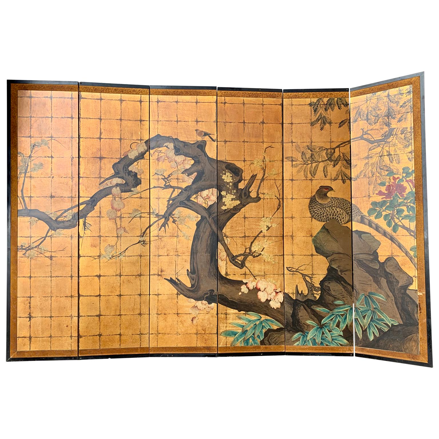 Large six-panel room divider screen with gilt and polychromed lacquered wood. The panels have hand painted Japanese inspired motifs of birds and flower decoration.
 