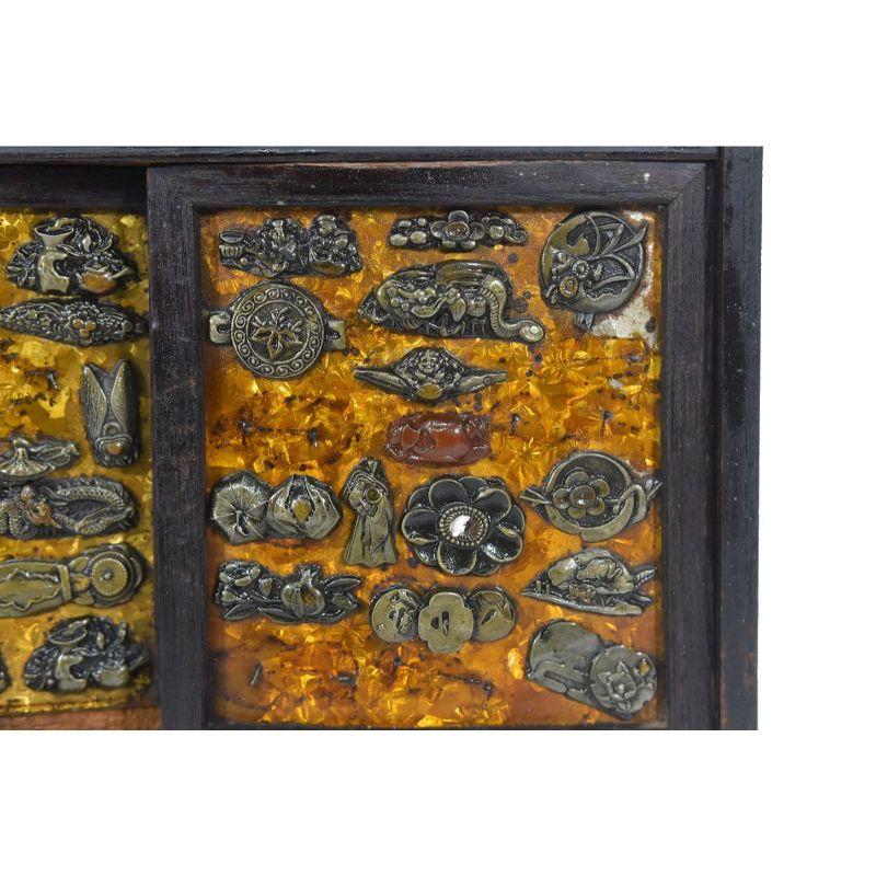 Boîte à bijoux Japon 1890/1900 décorée d'une centaine de Menukis en laiton repoussé et incrustations mesurant hauteur 33 x 33 x 15 cm. Les menukis sont des pièces ornementales qui décorent la tsuka (poignée) d'un katana (sabre japonais). Le plus