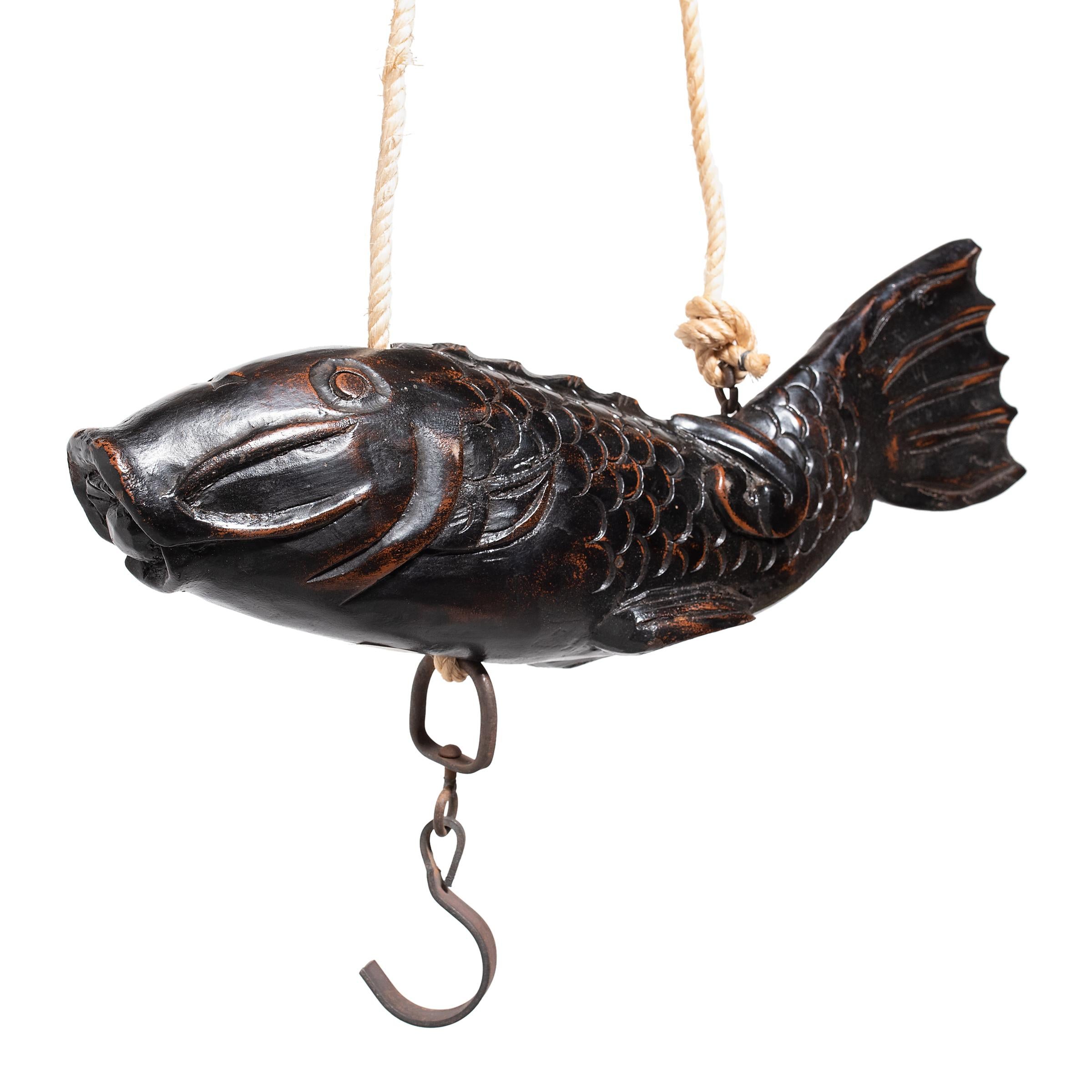 This lively wooden fish dates to the mid-19th century and was originally the lever mechanism on a traditional Japanese hearth hook, called a jizai kagi. Hung from the ceiling above an indoor floor hearth (irori), jizai kagi pothooks were used to