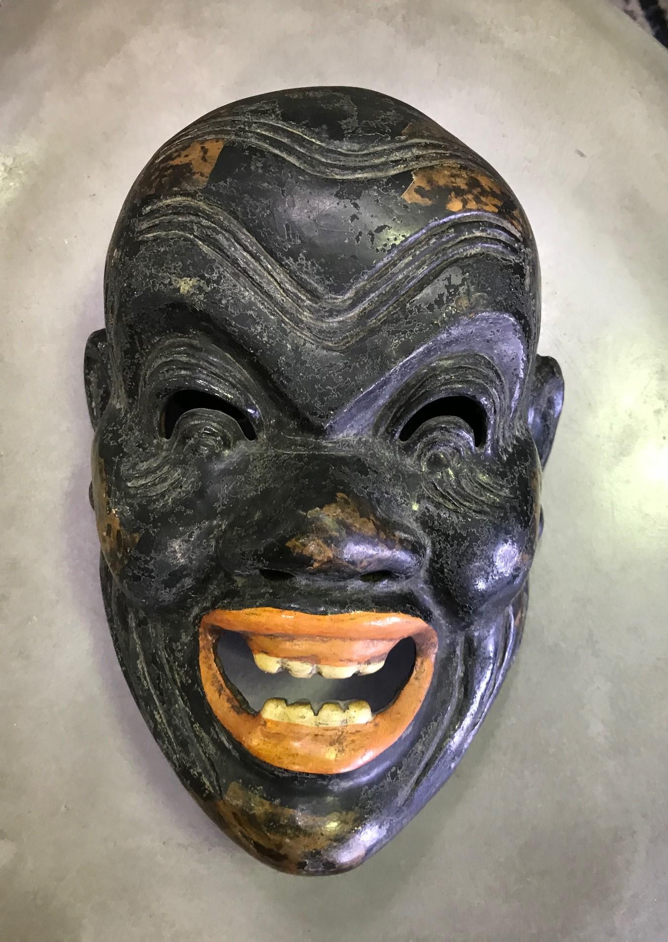 A rather wonderful, albeit a little frightening, Japanese Kagura mask, clearly made for and used by a Japanese Noh theater actor.

The mask is handcrafted. The maker uses a process of hemp cloth mixed with wood dust and lacquer so that the mask is