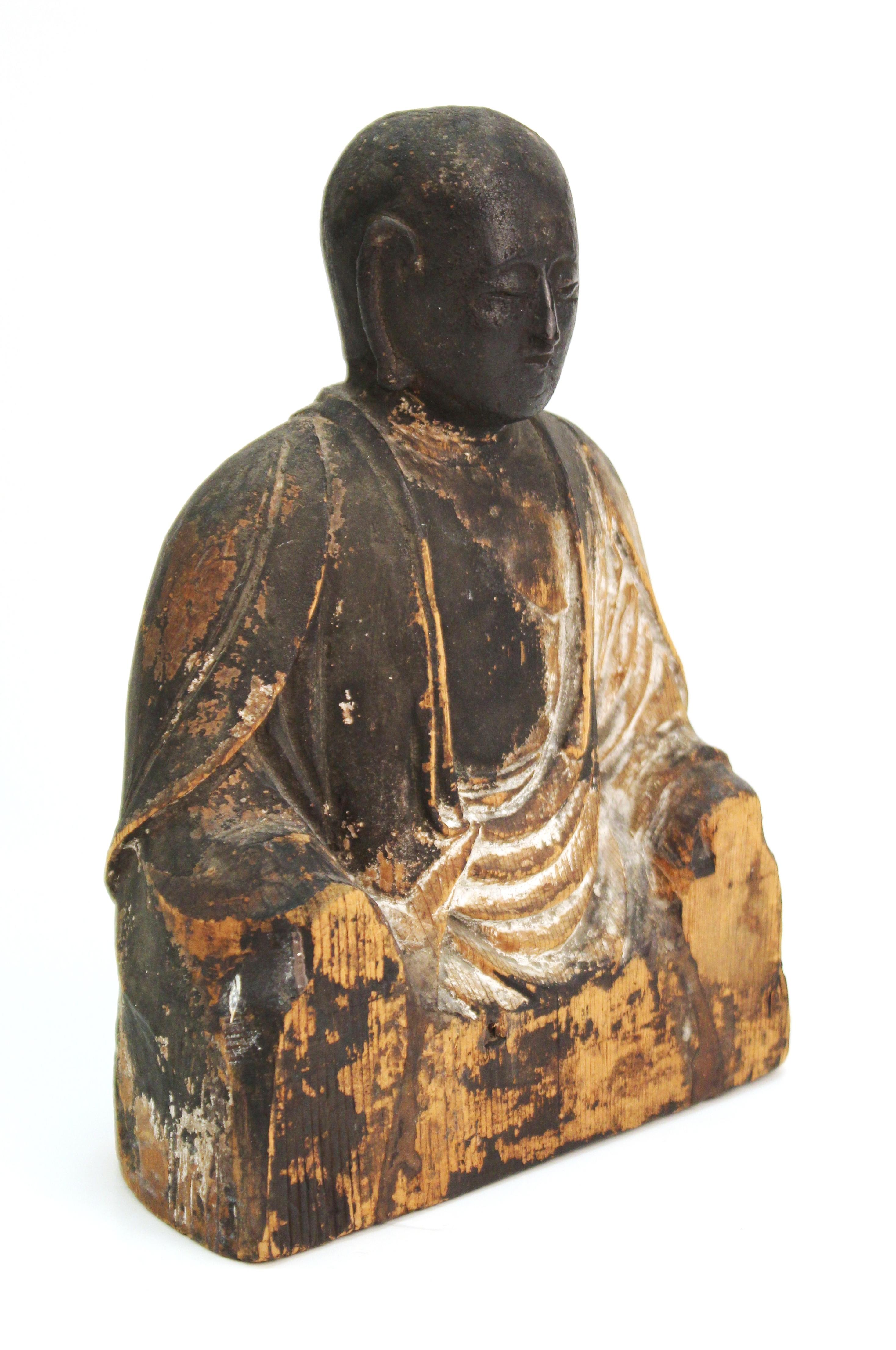 Japanese Heinan - Kamakura period seated sculpture of a Jizo Bosatsu Buddha made of carved wood. The sculpture dates to the 10th-12th century and has traces of antique paint on it. In great antique condition with age-appropriate wear and use.