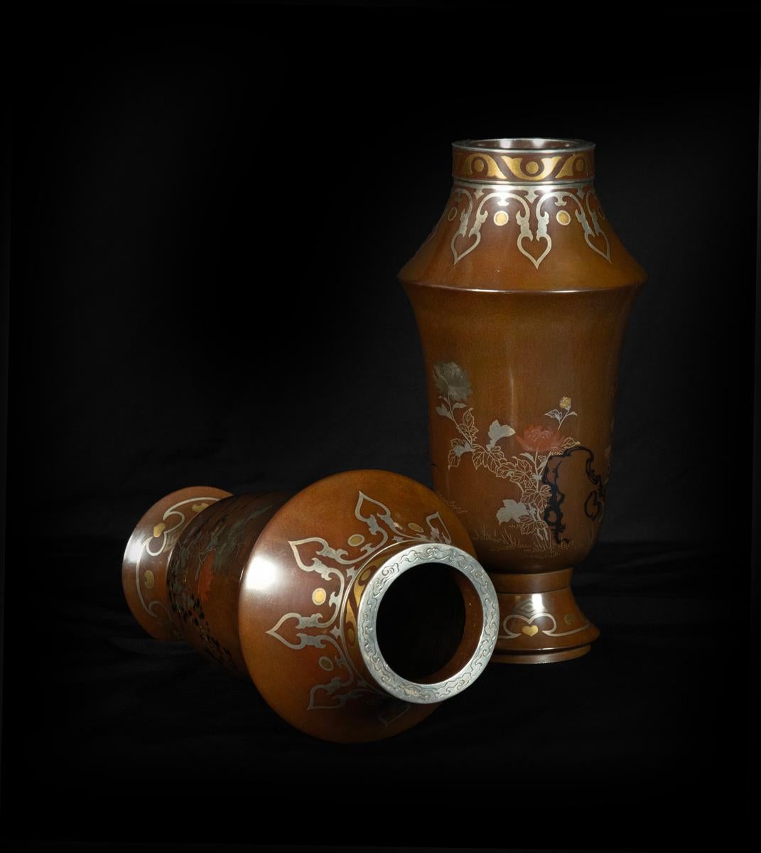 As part of our Japanese works of art collection we are delighted to offer this unusual shape heavy quality pair of early Meiji Period (1868-1912) bronze and mixed metal inlaid vases stemming from the Kanazawa school of metalworkers, based in