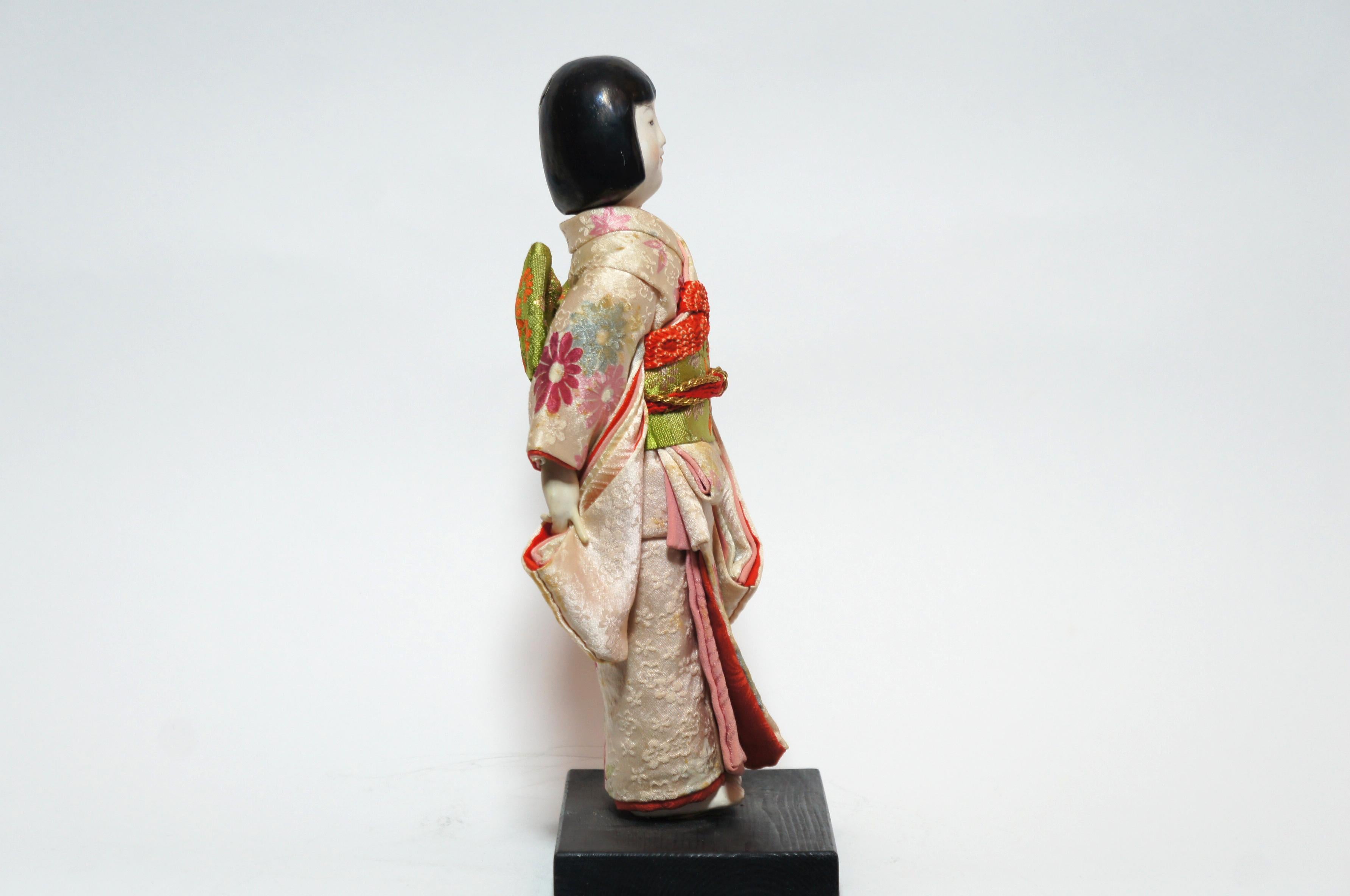 Kimekomi dolls are dolls made of wood (traditionally willow). 
The clothes are glued orforced into a slot in the base of the doll.
The dolls are contemporary of the Japanese poet and painter Yumeji Takehisa (1884-1934) and are inspired by his