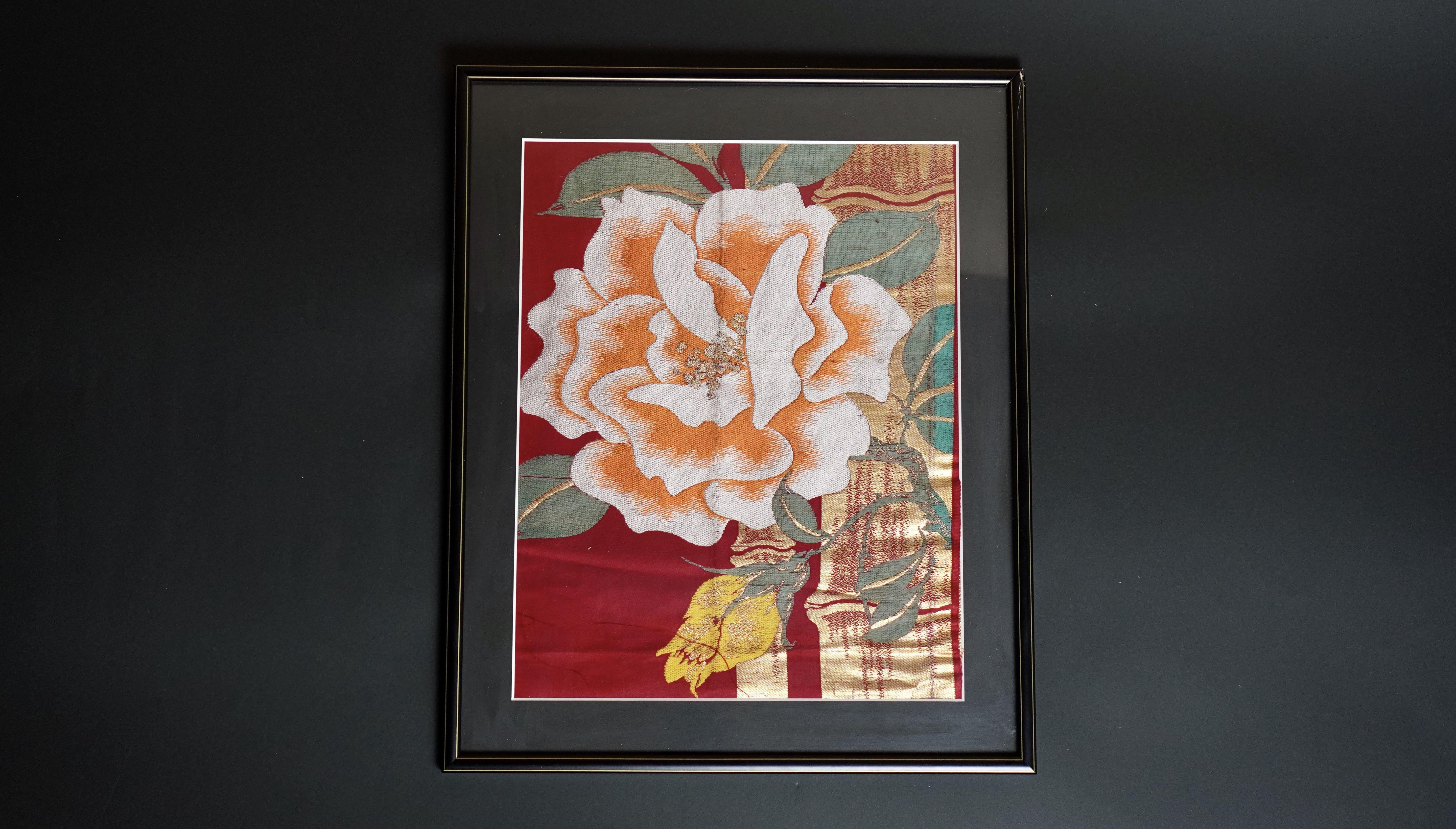 Diese Stickerei, für die ein Kimono-Obi verwendet wurde, der nach traditionellen japanischen Methoden gewebt wurde, ist ein beeindruckendes Kunstwerk mit einer schönen Rose und goldenem Bambus.

 Die Rose wird von vielen Menschen als Symbol für