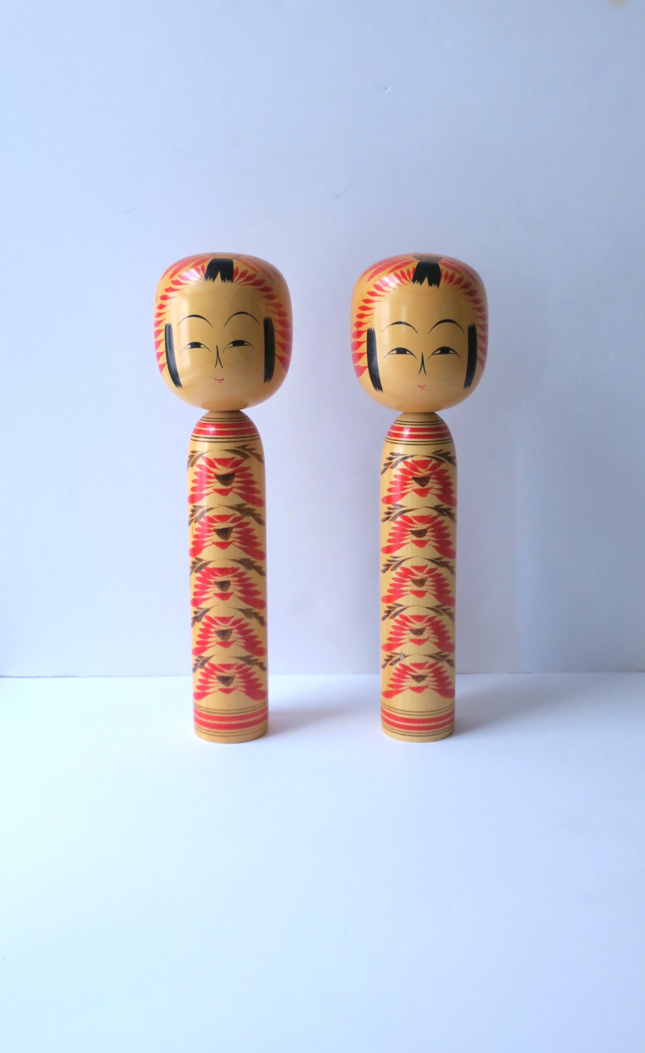 Ein Paar authentischer, signierter japanischer Kokeshi-Holzpuppen, ca. Mitte des 20. Jahrhunderts, Japan. Die Formen und Muster der Puppen sind für ein bestimmtes Gebiet typisch und werden in elf Typen eingeteilt; diese Puppe ist ein Sakunami-Typ,