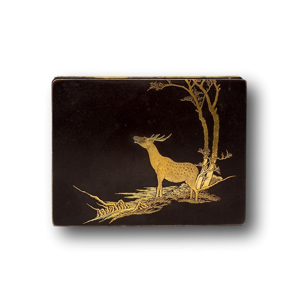 A fine Japanese Meiji period box in the Komai style. The box of deep rectangular shape with hinged lid worked beautifully with gold and silver nunomezogan on a matt black ground. To the lid a deer looks up with a silver snout amongst inlaid gold