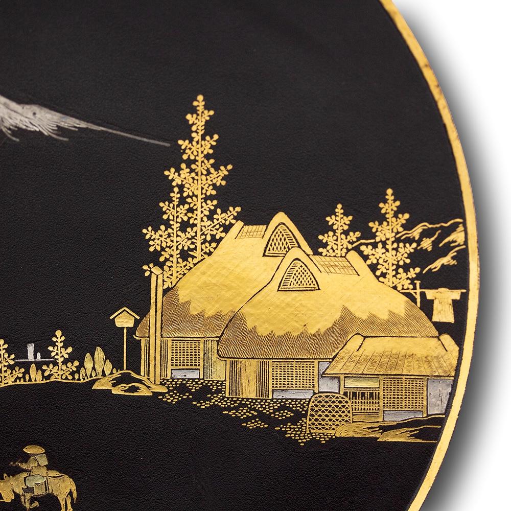 Japanese Komai style iron damascene dish. The dish decorated with a landscape scene worked in gold and silver nunomezogan on a matt black ground with a village scene and Mount Fuji rising through in the distance. Two figures walk towards the village