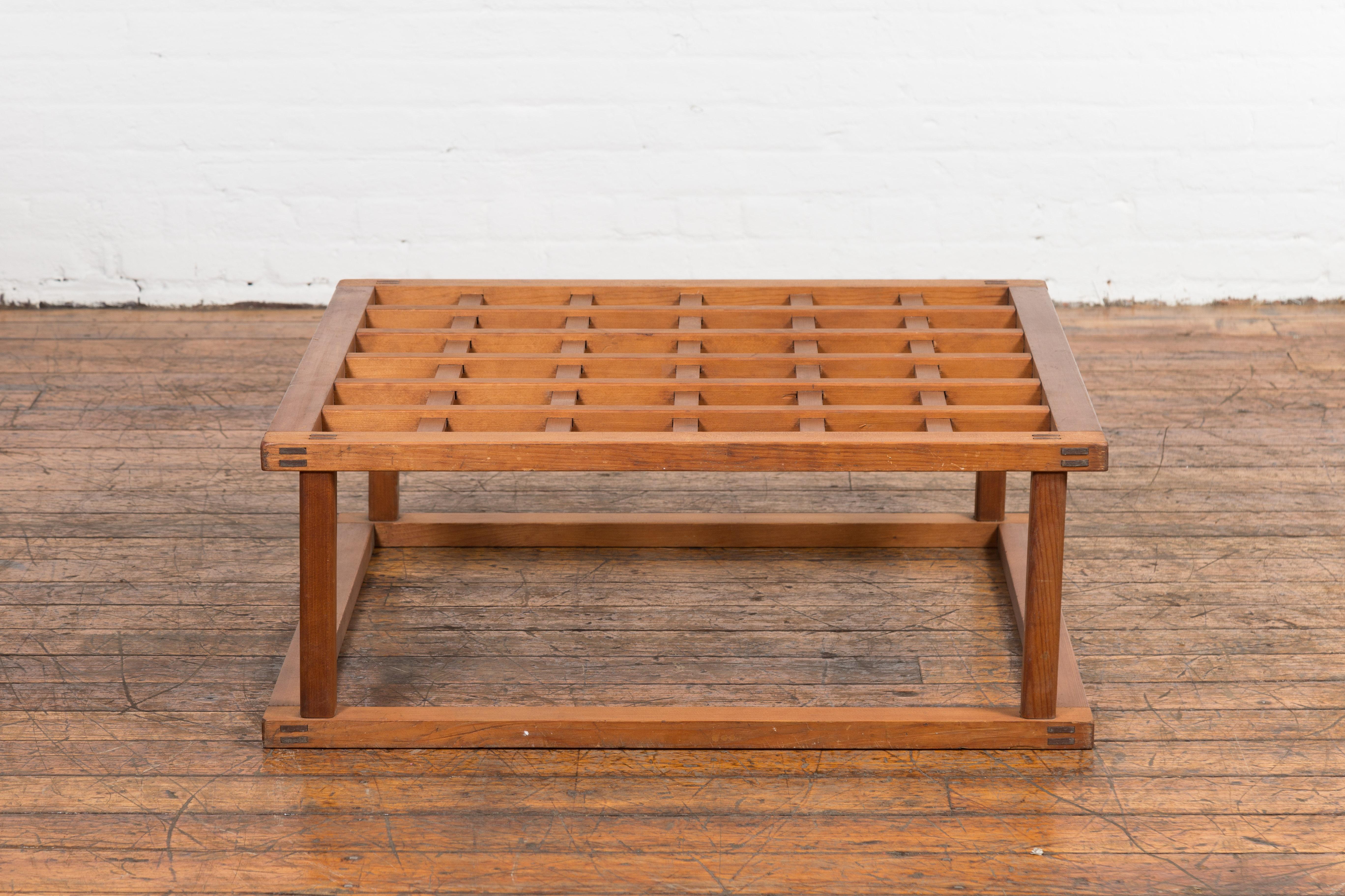 A vintage Japanese hinoki wood Kotatsu coffee table from the mid 20th century with square openwork top, linear silhouette and natural finish. Unfolding an eloquent simplicity, this vintage Japanese Hinoki wood Kotatsu coffee table, hailing from the