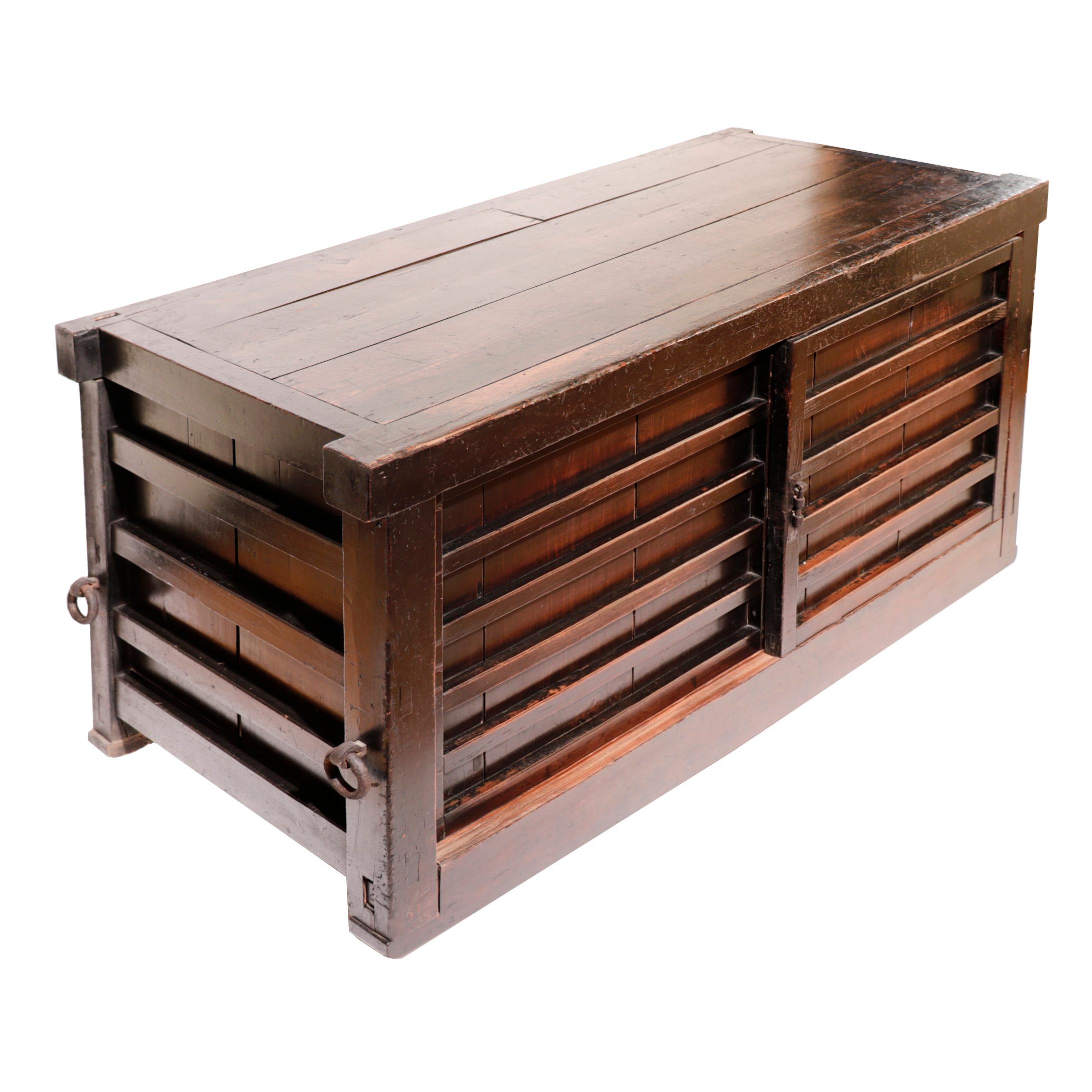 Kuruma-dansu japonais, coffre de rangement à roulettes traditionnellement conservé dans la Kura (réserve) dans le but spécifique de contenir des objets de valeur, d'où le chariot à roulettes permettant une sortie rapide en cas d'incendie. Cette