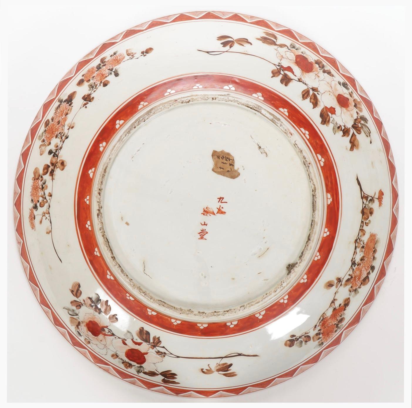 A large Japanese Meiji porcelain charger with figural details and flowers. 

Measures: diameters: 14.5 in.
