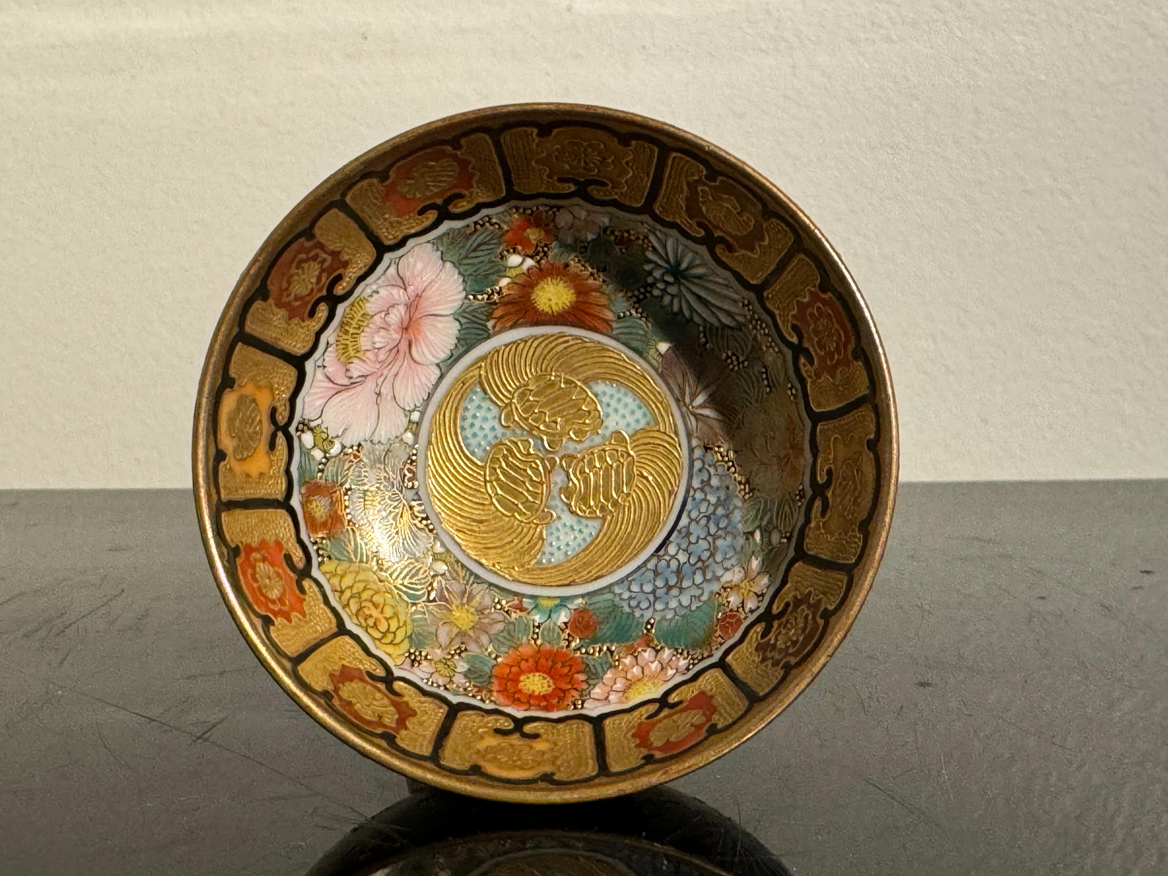 A fantastic small Japanese Kutani porcelain sake cup decorated with a millefleurs pattern, Taisho Period (1912 - 1926), circa 1920, Japan. 

The small circular cup set on a short recessed foot. The fine porcelain painted all over in stunning enamels