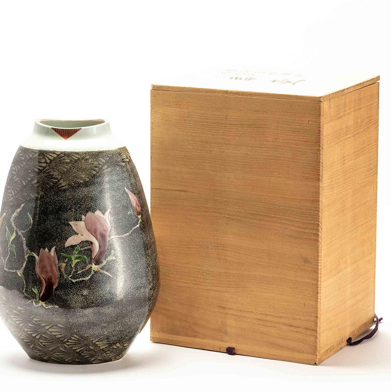 Japanese Kutani porcelain studio vase by Nobuhiko Sueoka (b. 1948). hand painted in the Kutani style with an elegant magnolia blossom motif on a textured stippled black background. 

Born in Fukuoka, Nobuhiko studied under Living National Treasure