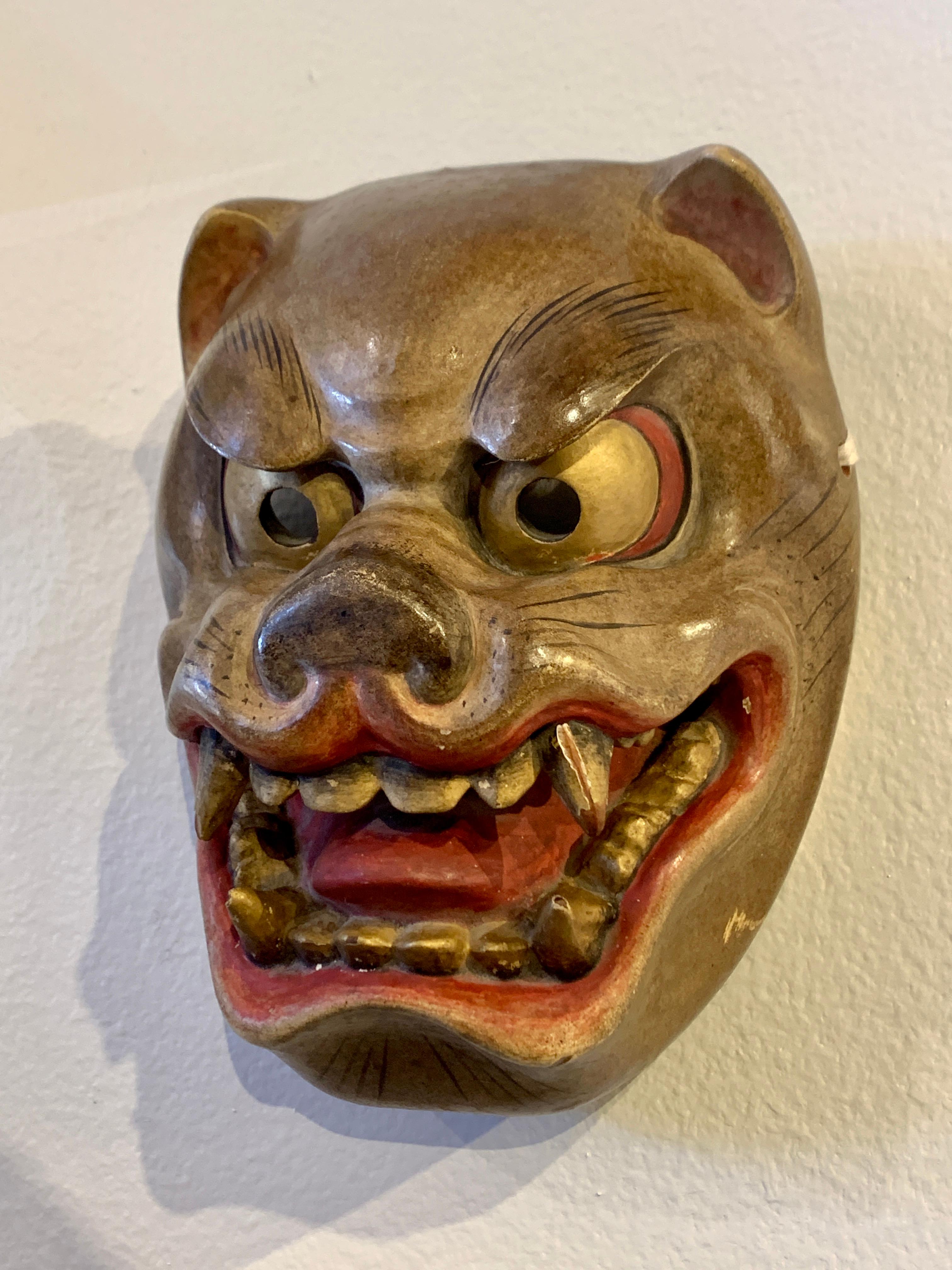 A fantastic and expressive Japanese carved wood mask of a tiger, made for kyogen theater performances, Showa Era, mid 20th century, Japan.

The tiger mask has been carved with wild and dramatic expressions. The tiger's mouth is open, fangs bared