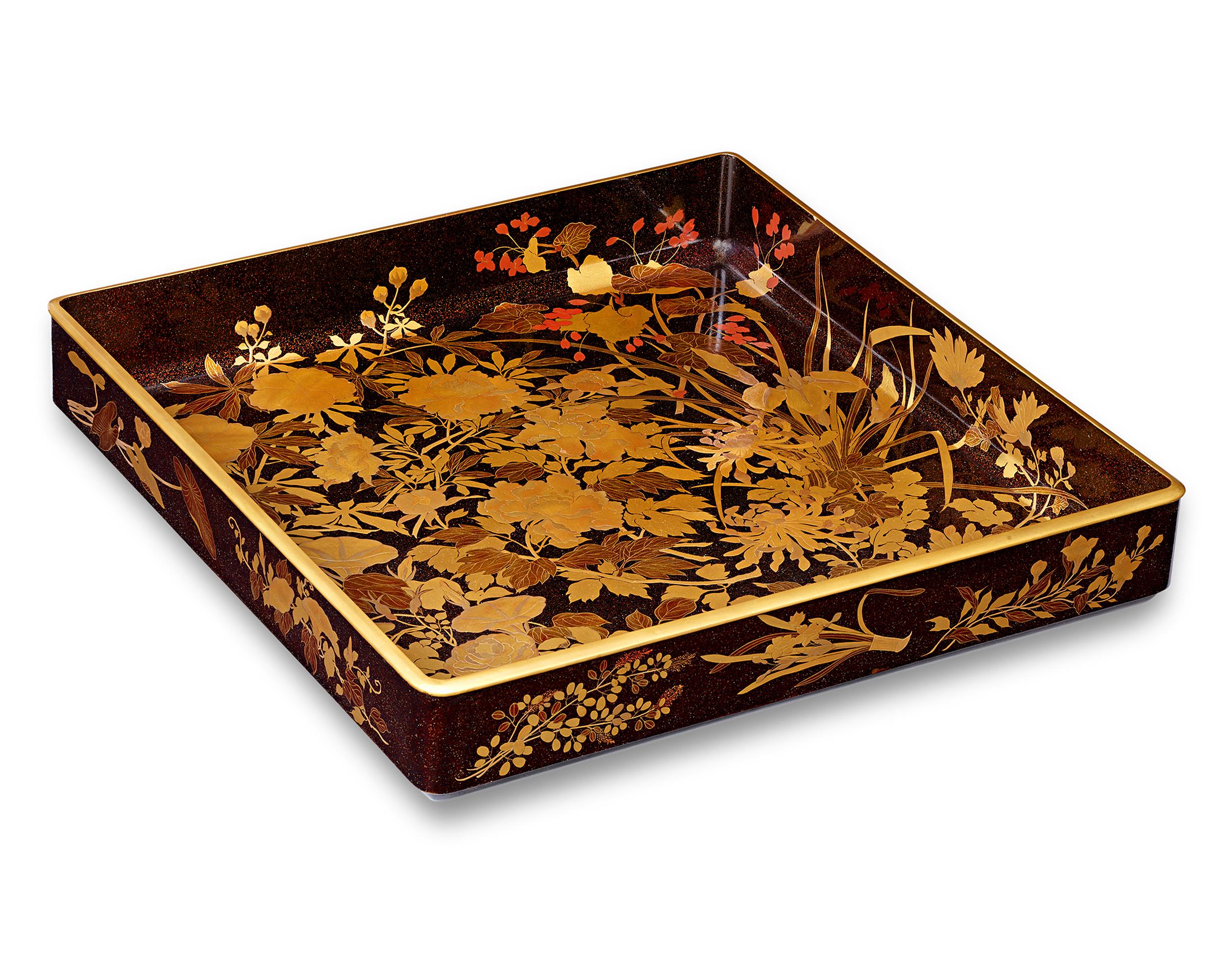 This Meiji-period lacquer tray represents the mastery of Japanese craftsmen in the art of lacquer work. Precious materials are precisely inlaid in the lacquer base, creating a highly illusionistic three-dimensional effect. Gold lacquer borders the