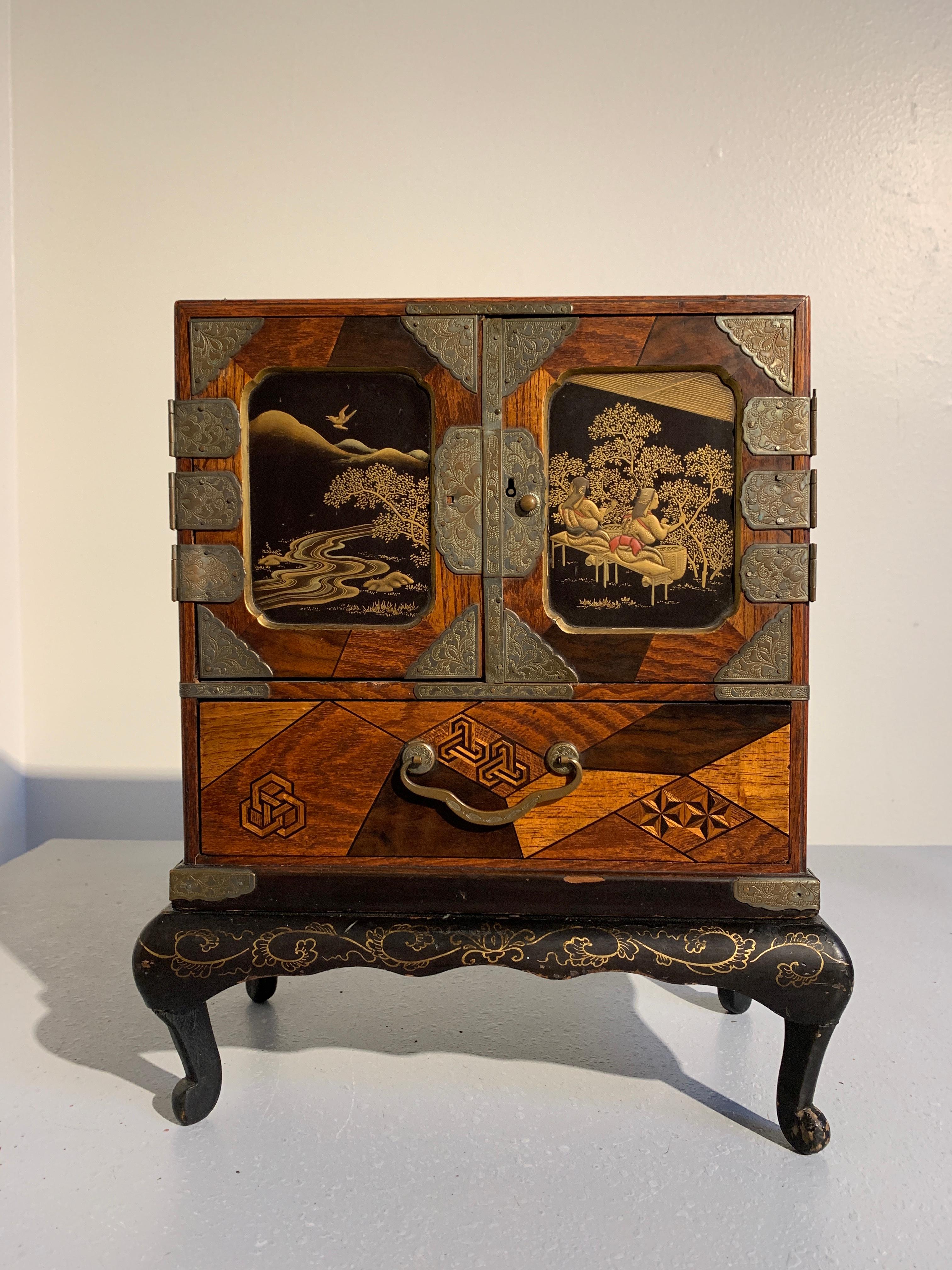 A fine Japanese Meiji Period miniature tansu, known as a hairbako, featuring exquisite lacquer decorated doors and beautiful marquetry work, circa 1890. 

A haribako is a sewing, jewelry or trinket box, often modeled after larger clothing tansu.