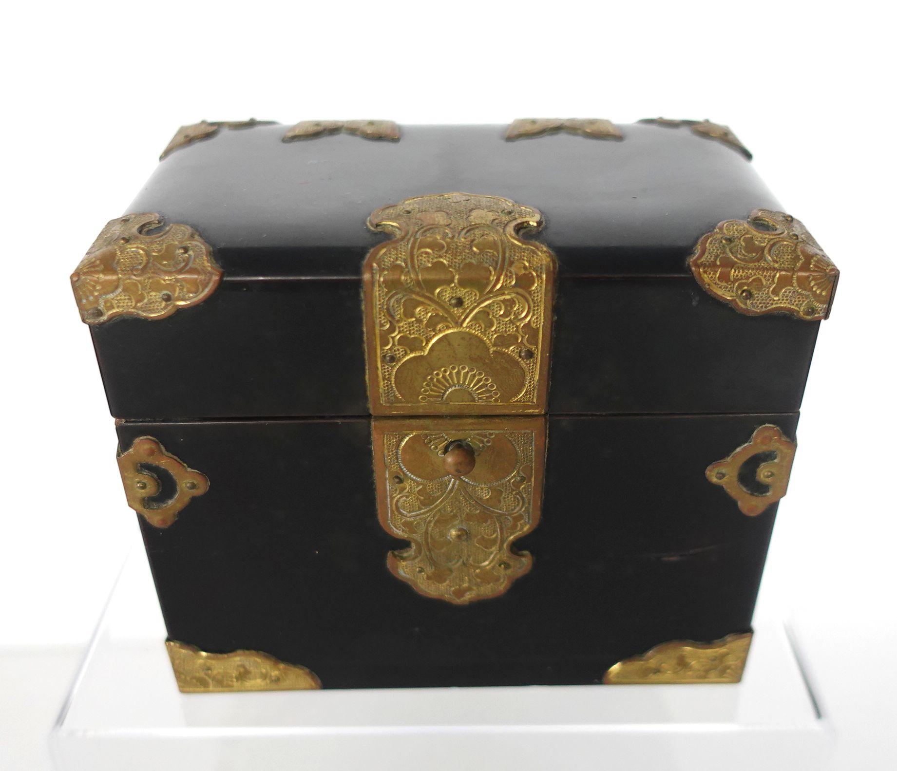 Black lacquer box with brass decorations opening to two compartments.