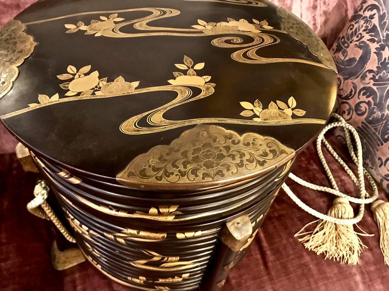 Beautiful Japanese Meiji period black lacquer and gilt lacquer hatbox. The hatbox is in overall very good to excellent condition with the box retaining its original chased brass detailing and tasseled silk cords.