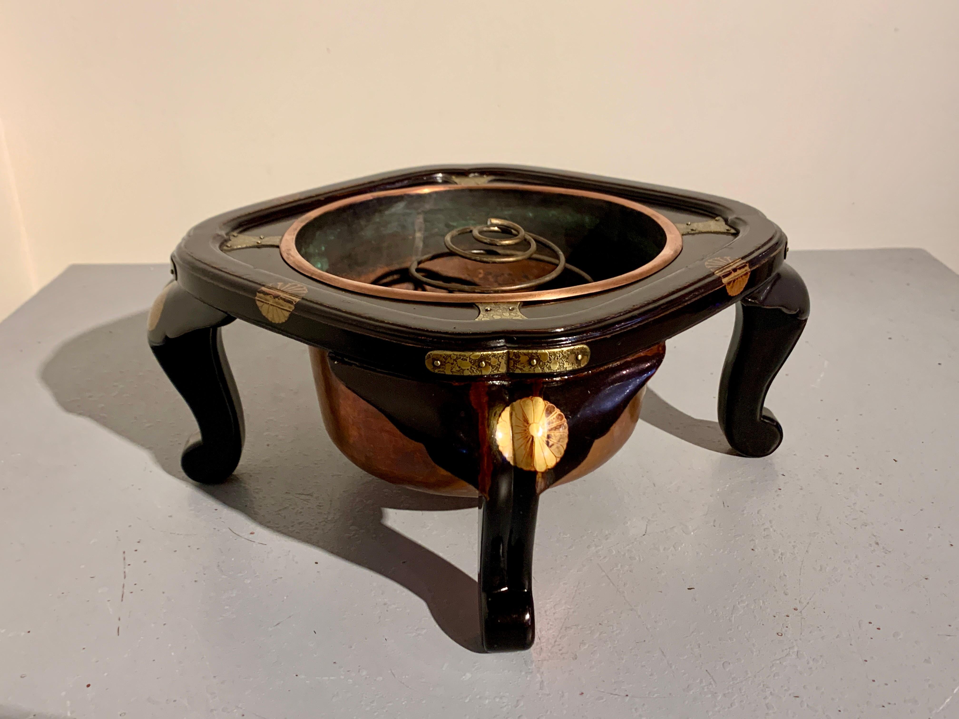 A simple and elegant Japanese lacquer hibachi stand with imperial chrysanthemum mon and copper liner, now modified as an usubata, late Meiji Period, circa 1900, Japan.

The refined black lacquer hibachi stand of low table or stand form, with