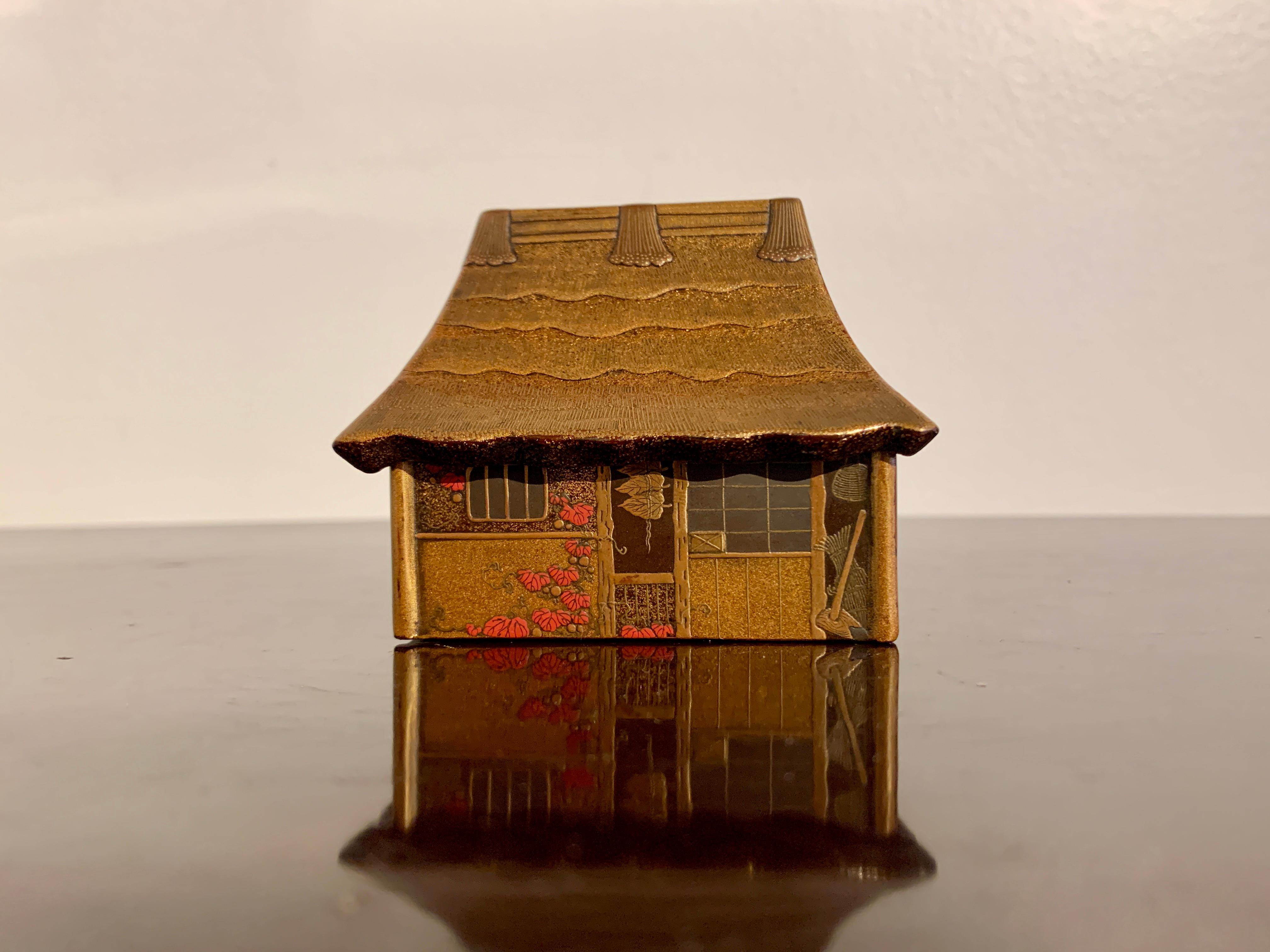 Eine reizvolle und aufwendig verzierte Lackdose zur Aufbewahrung von Weihrauch, kogo, in Form eines traditionellen Bauernhauses, Meiji-Periode (1864 - 1912), Ende 19.

Die Kogo, eine kleine Kiste zur Aufbewahrung von Räucherstäbchen, hat die
