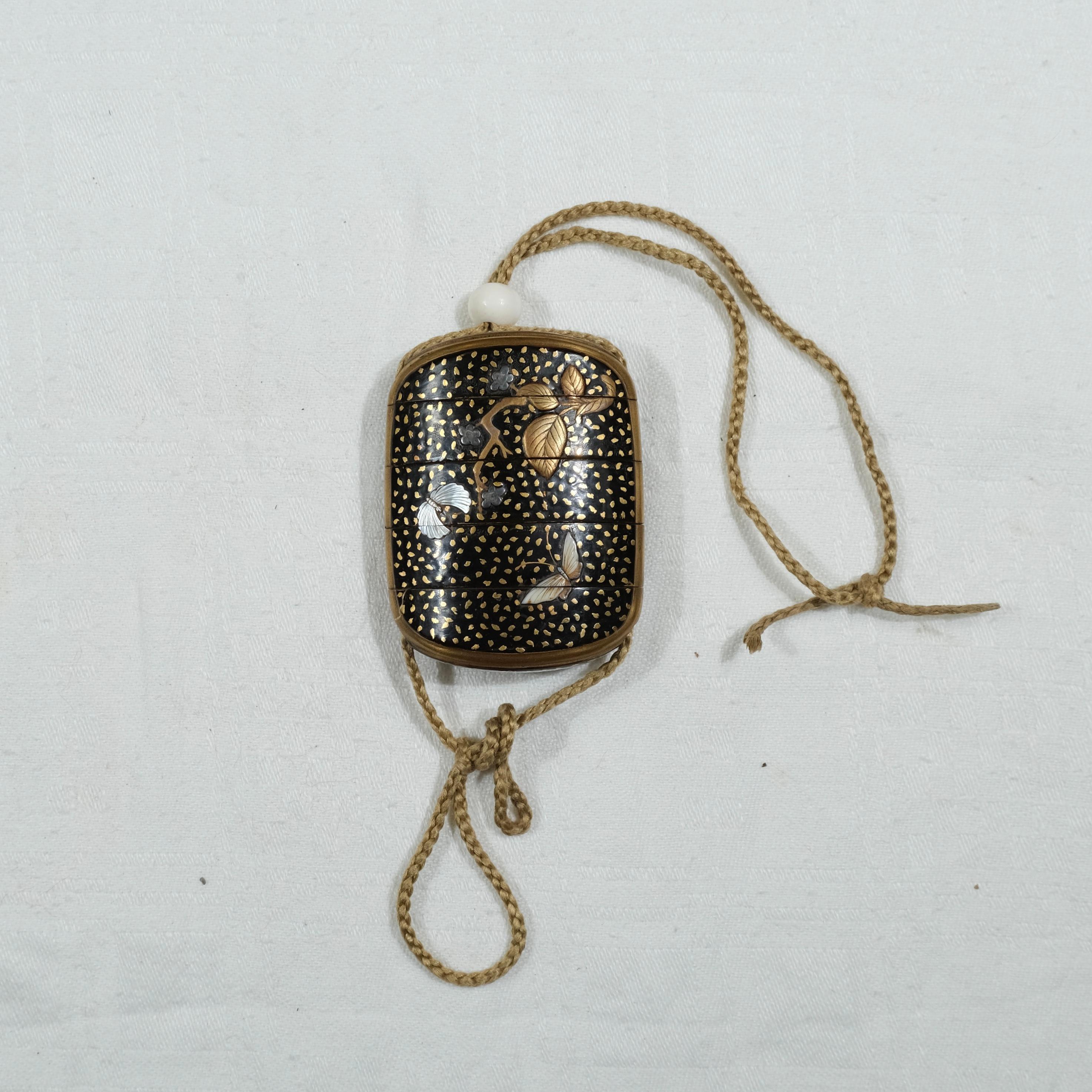 Inro japonés lacado en cinco partes, periodo Meiji , finales del s. XIX. Motivos de mariposas, hojas y flores. Firma de los osos en la parte inferior.