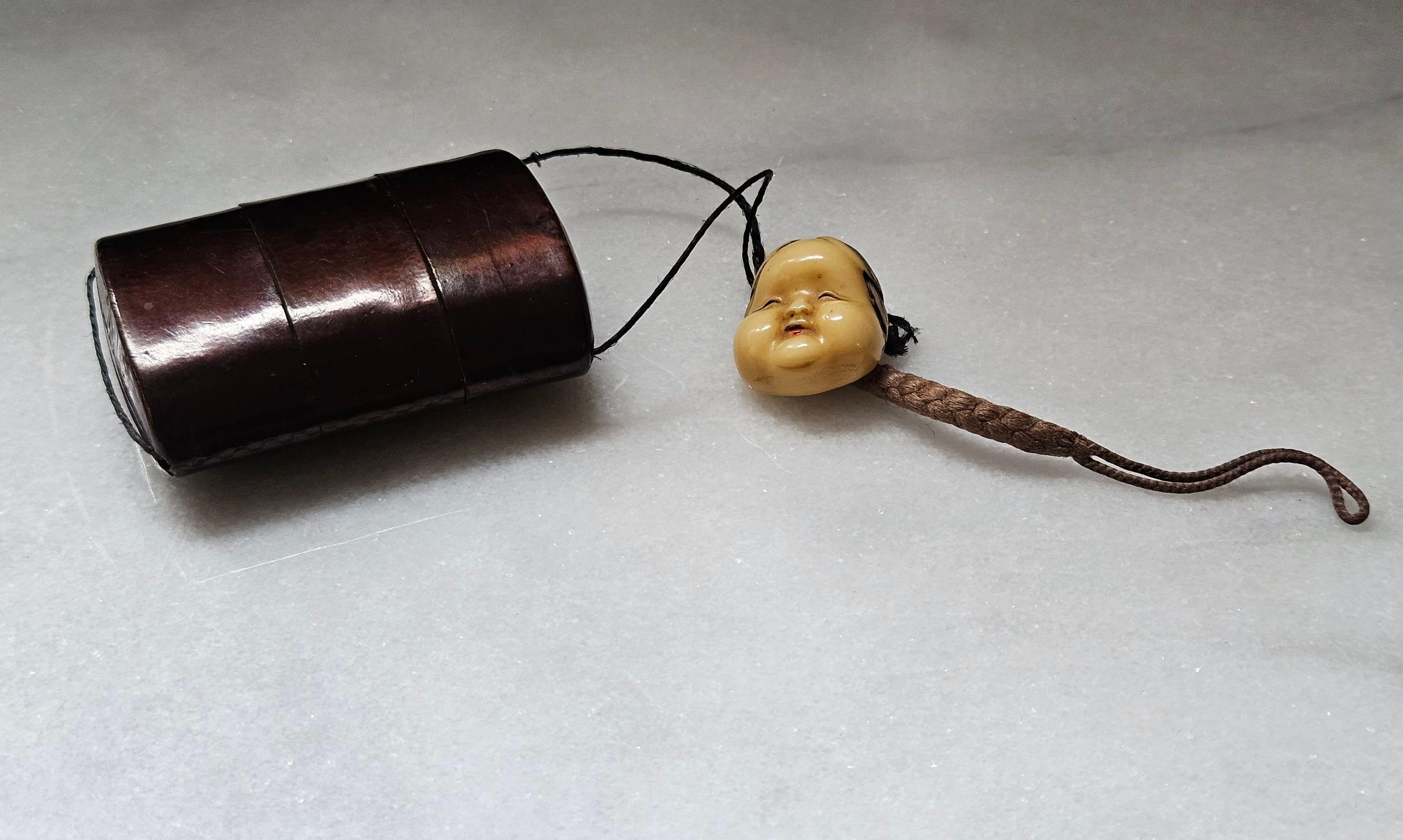 Japanese Lacquer Inro with Netsuke Okame Mask, brown lacquer with 3 sections and 2 compartments, and carved ivory polychrome Okame mask and a rope hair. This item is from the Meiji Period.

Dimension:  
Inro: 1.5