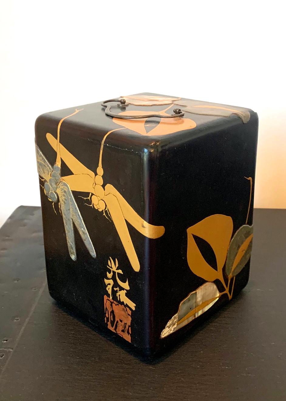 A beautiful Japanese jewelry box in the form of a portable cabinet with handle on top, a removable door and three inner drawers. The lacquered box was lavishly decorated on surface in the Rinpa School style. In contrast with a black kuro urushi