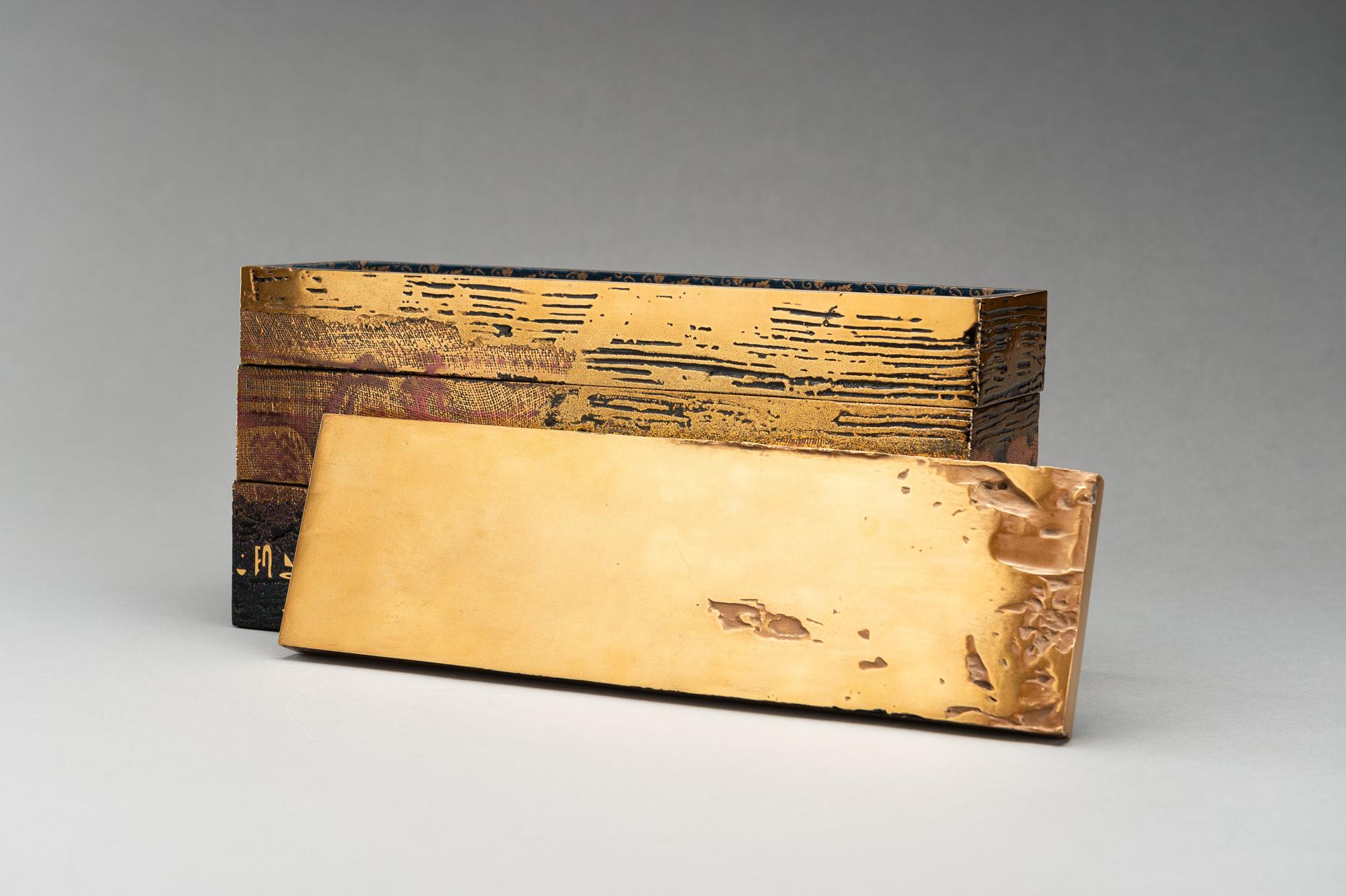 Eine außergewöhnliche, längliche, dreistöckige Lackbox mit Deckel, die an eine Bento-Box erinnert, von Hiroshi Hayashi (1967). Überzogen mit glänzendem Gold und schwarzem Lack mit roten Akzenten. Die Oberfläche mit verschiedenen Texturen, die